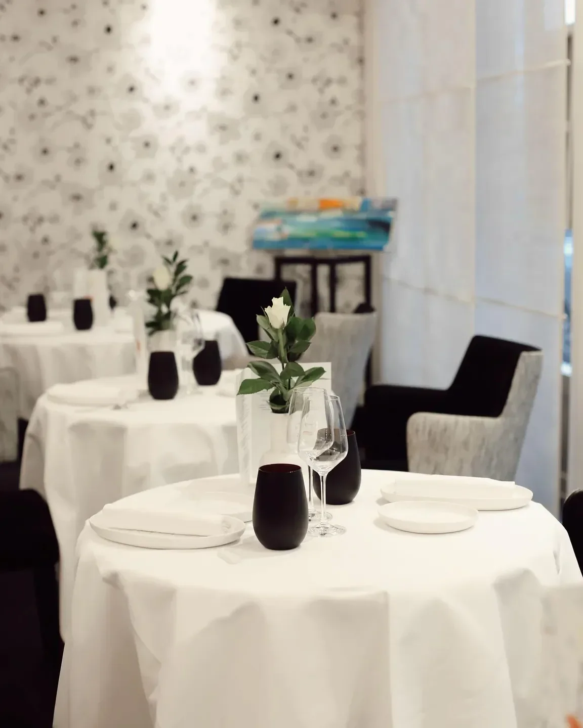 Elegant dining at Le Gourmet de Sèze in Lyon, with tables set and floral decorations.