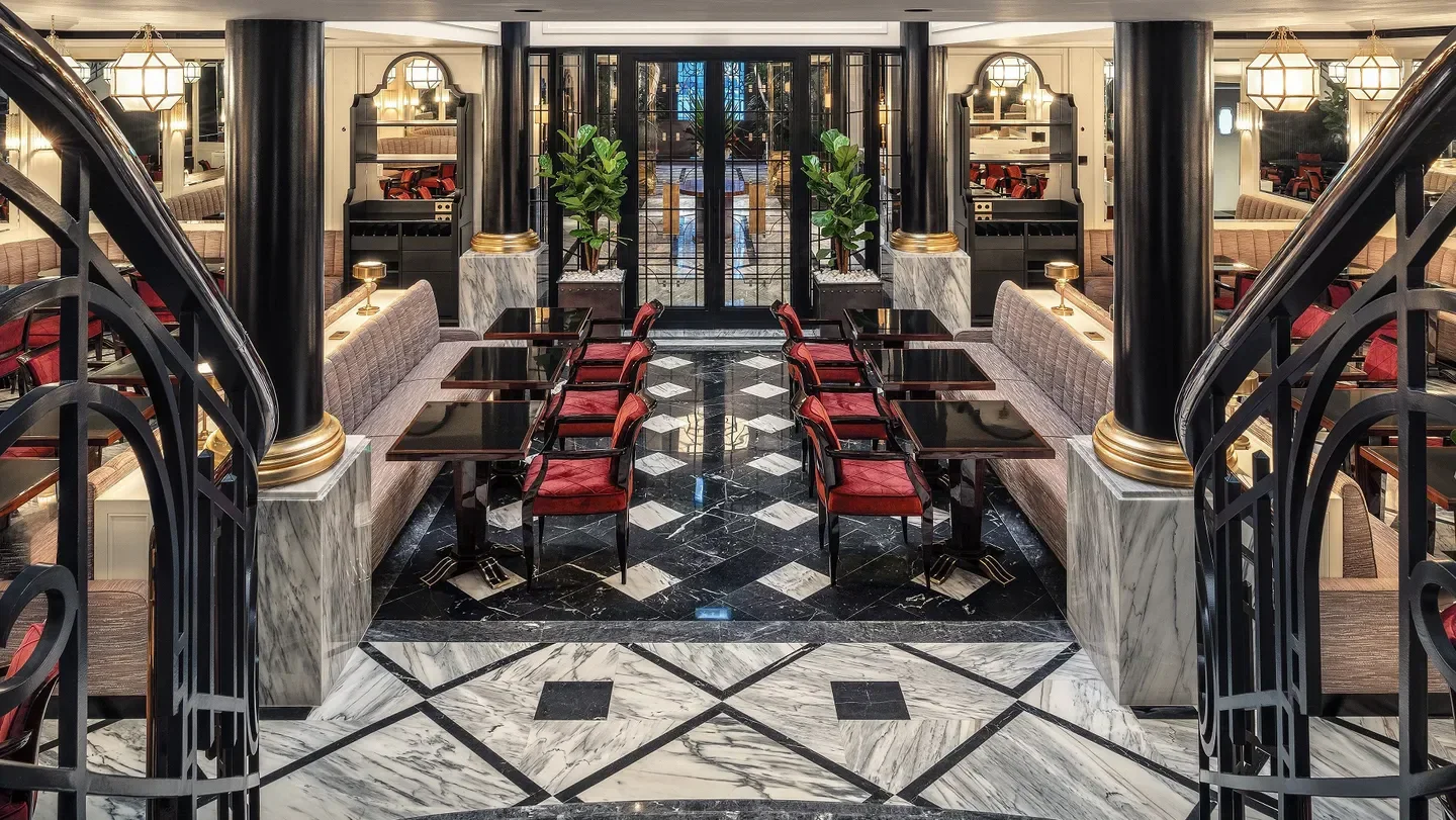 Elegant interior of Le Monument restaurant in Porto with red chairs and marble floor