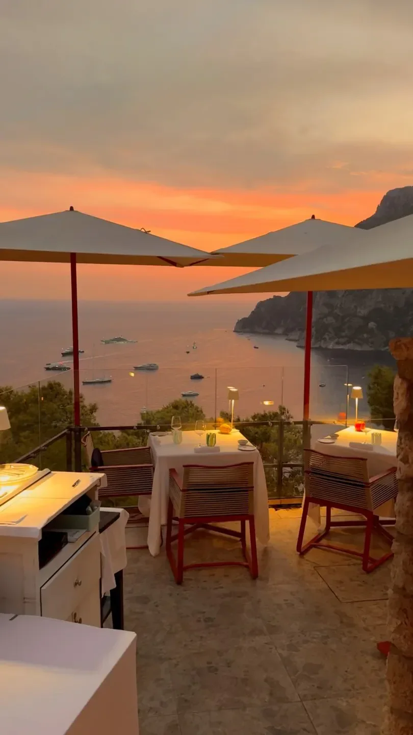 Le Monzù Capri restaurant terrace at sunset with stunning sea views and outdoor tables