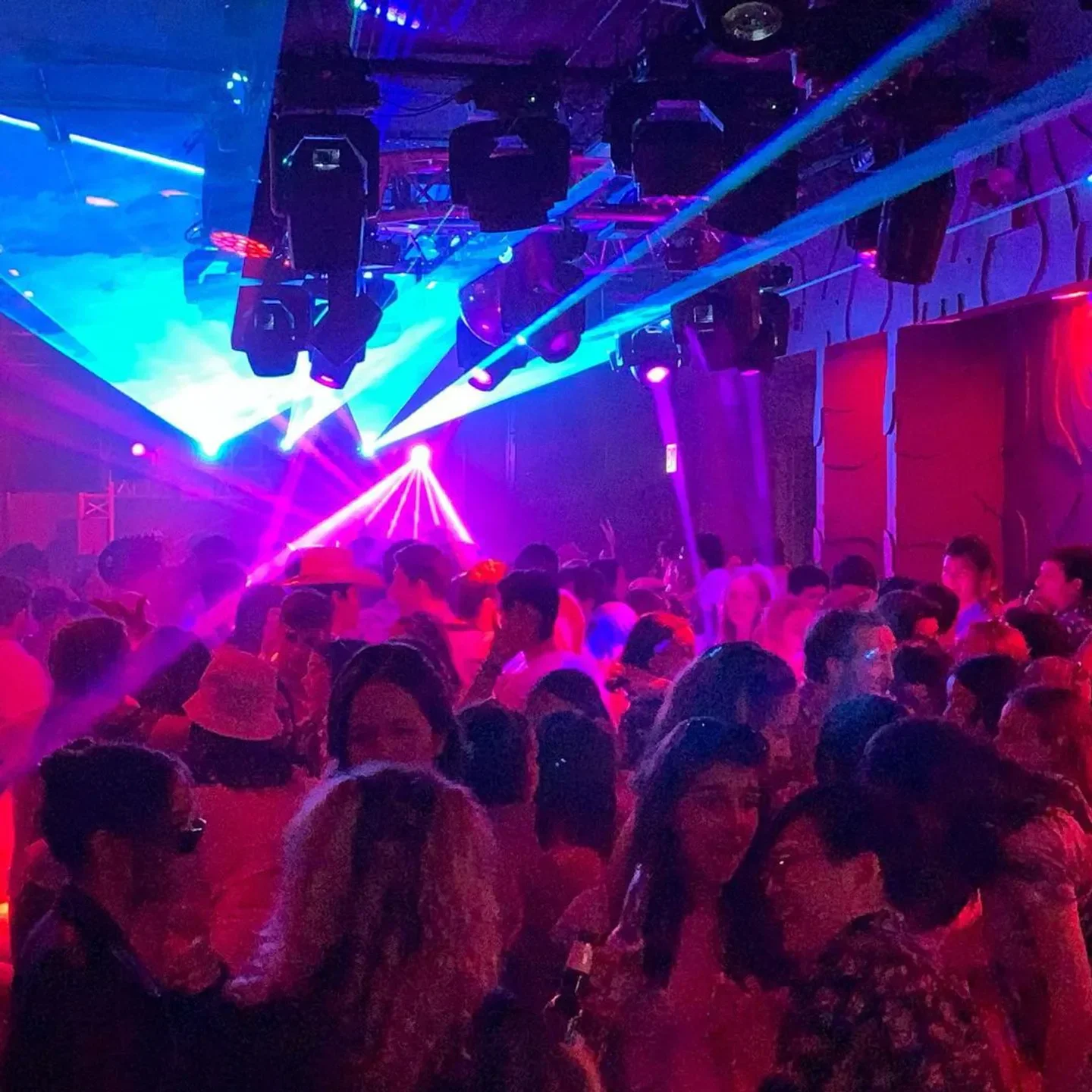 Energetic crowd enjoying the night at Le Nocturne nightclub in Chicago, illuminated by lasers.