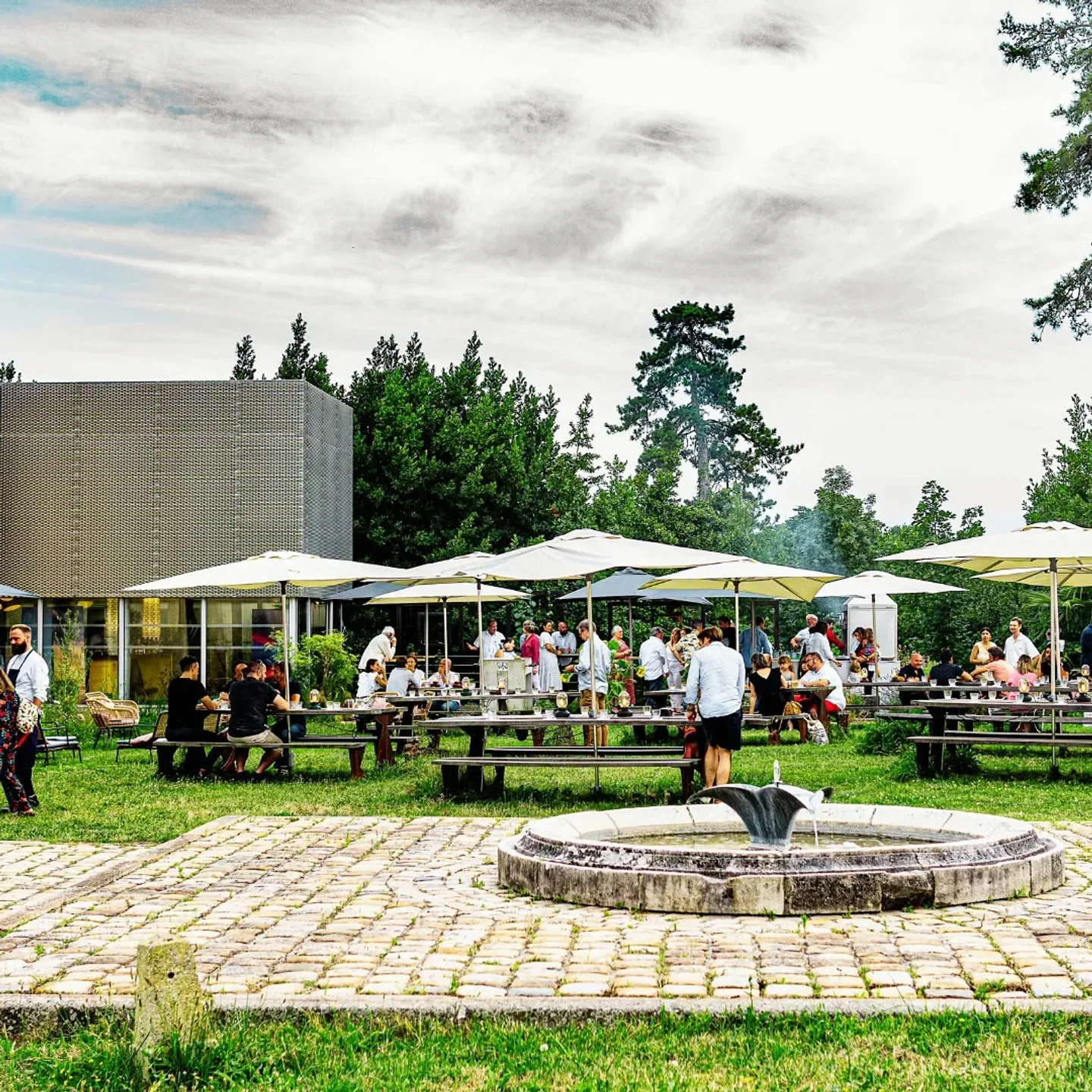 Outdoor dining at Le Prince Noir - Vivien Durand in Bordeaux, with fountain and umbrellas.