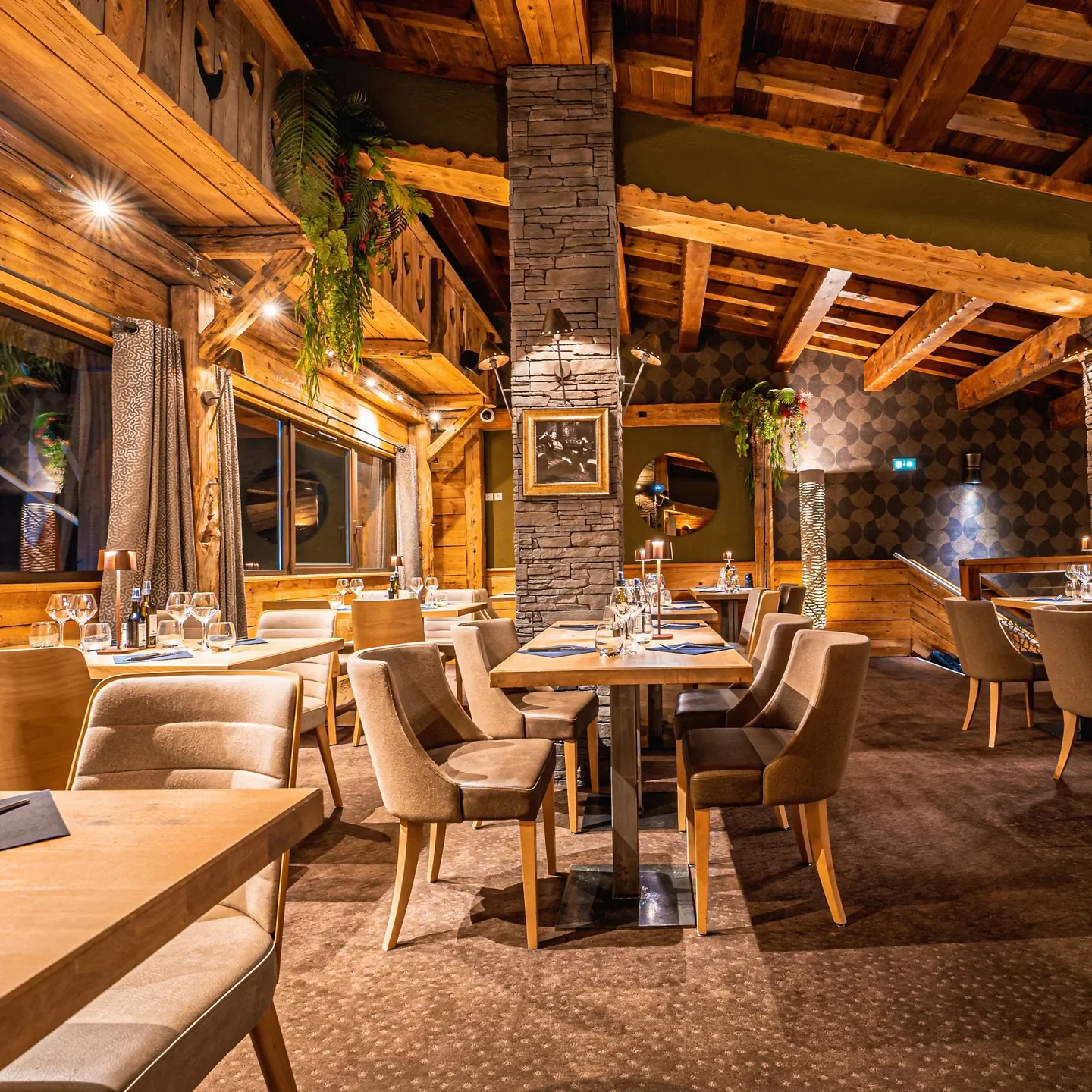 Cozy interior of Le Rendez vous restaurant in Val Thorens, with wooden beams and tables.