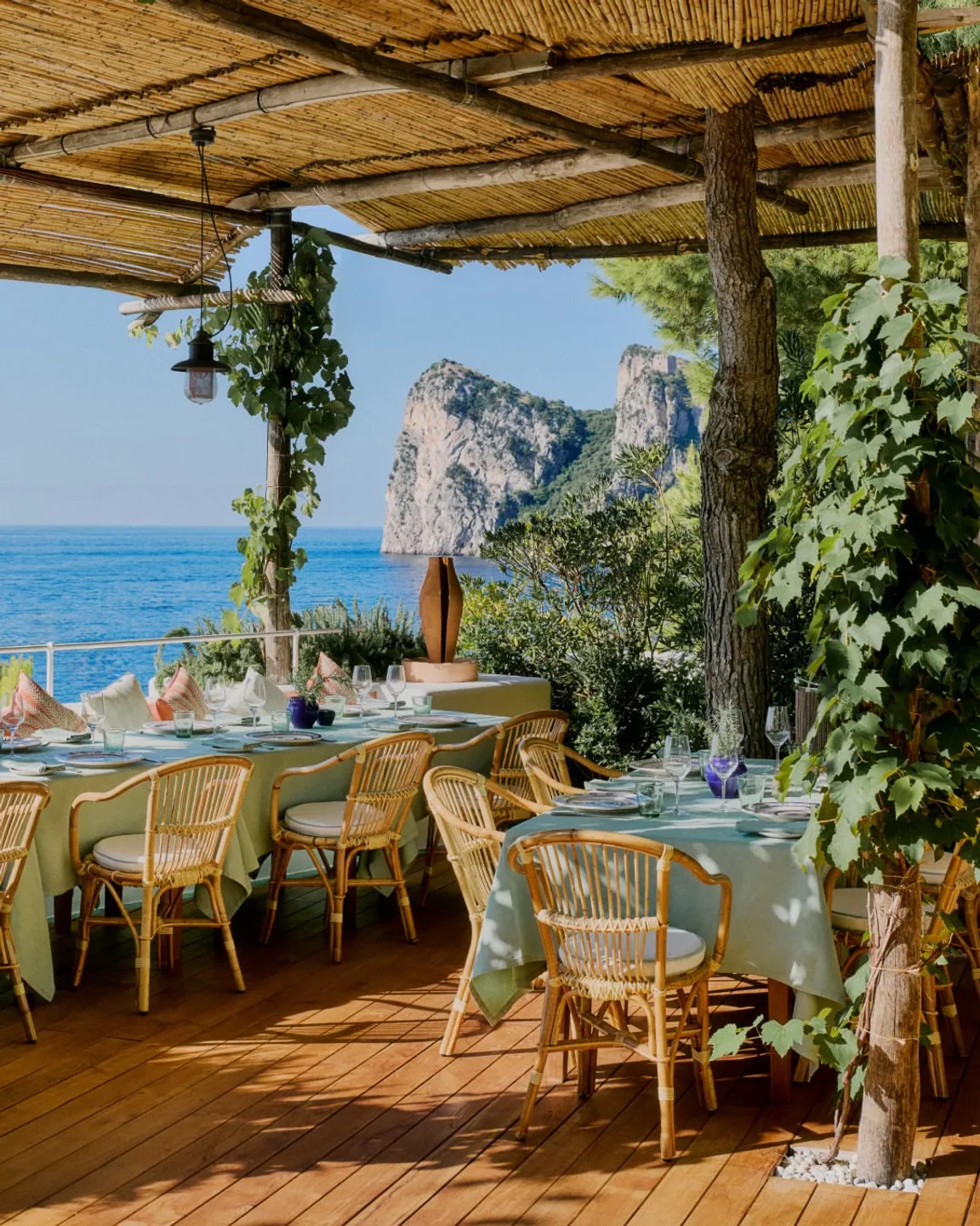 Le Sirenuse Mare beach club on Amalfi Coast with ocean view dining and rattan chairs.