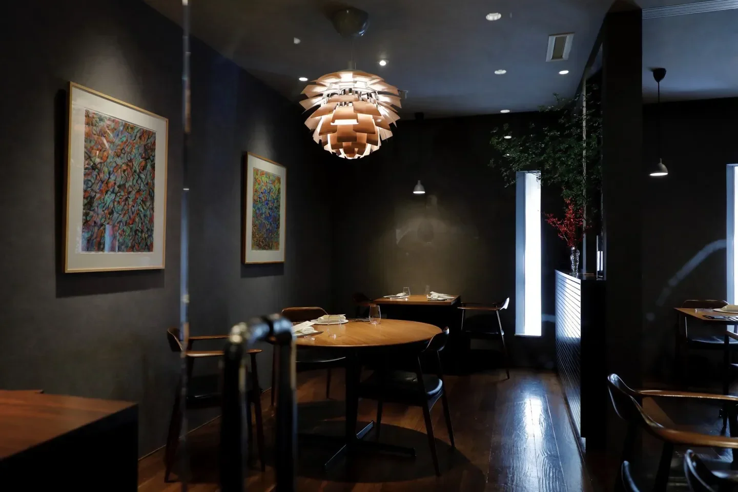 Interior of Le Sputnik restaurant in Tokyo, showcasing elegant dining space and art.