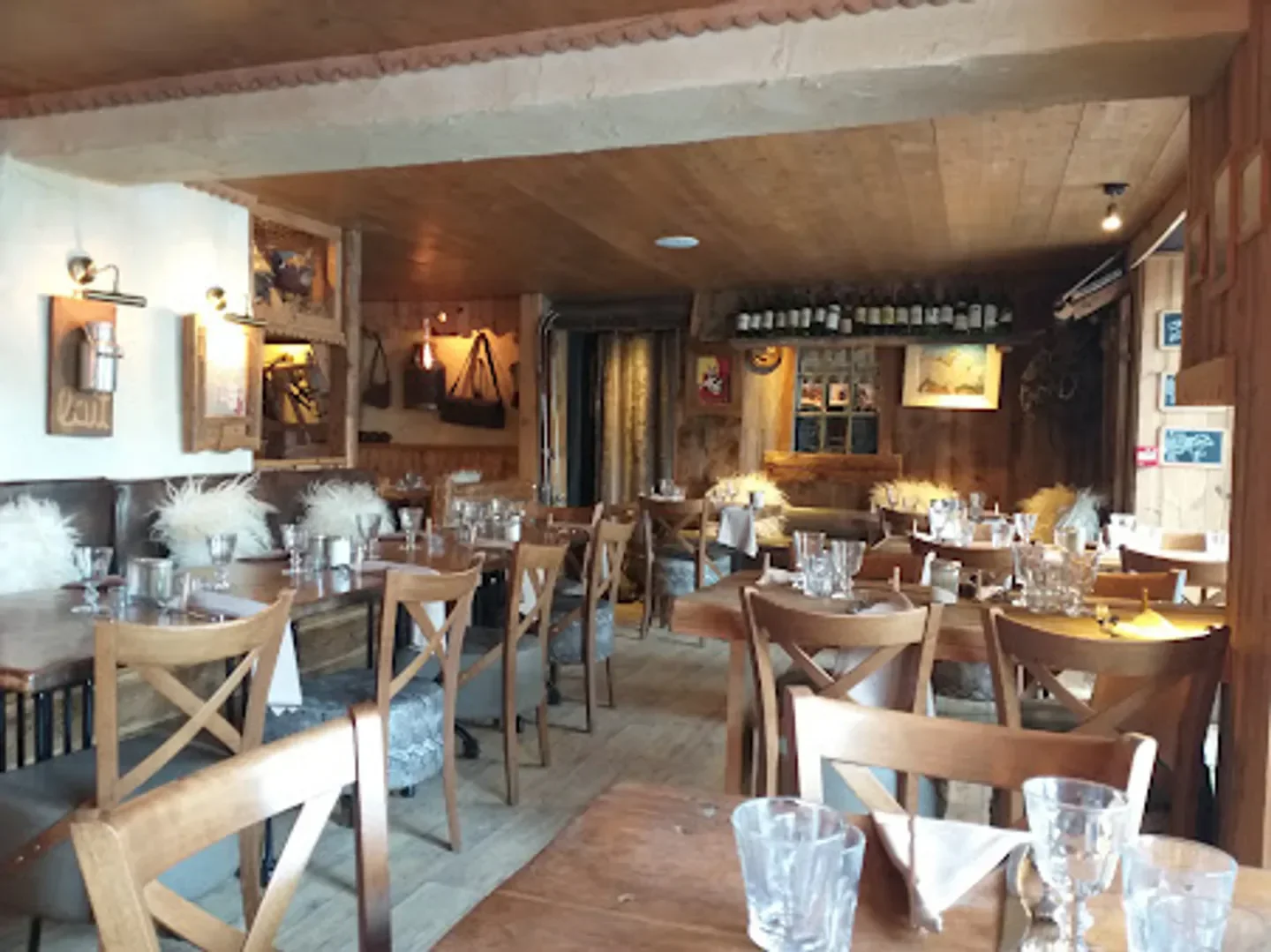 Cozy interior of Le Torrent restaurant in Megeve, featuring wooden tables and chairs.