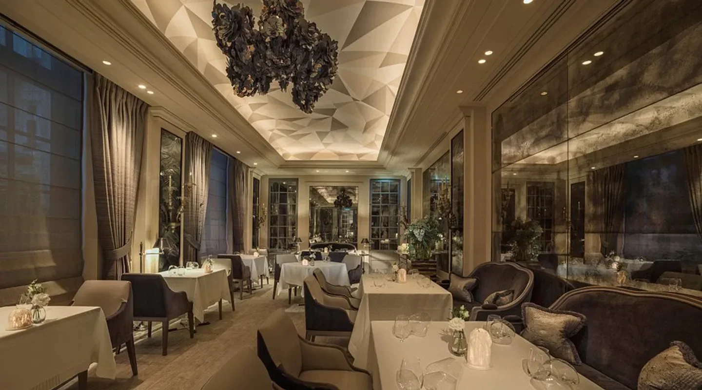 Elegant dining room interior at L'Ecrin restaurant in Paris with a geometric ceiling