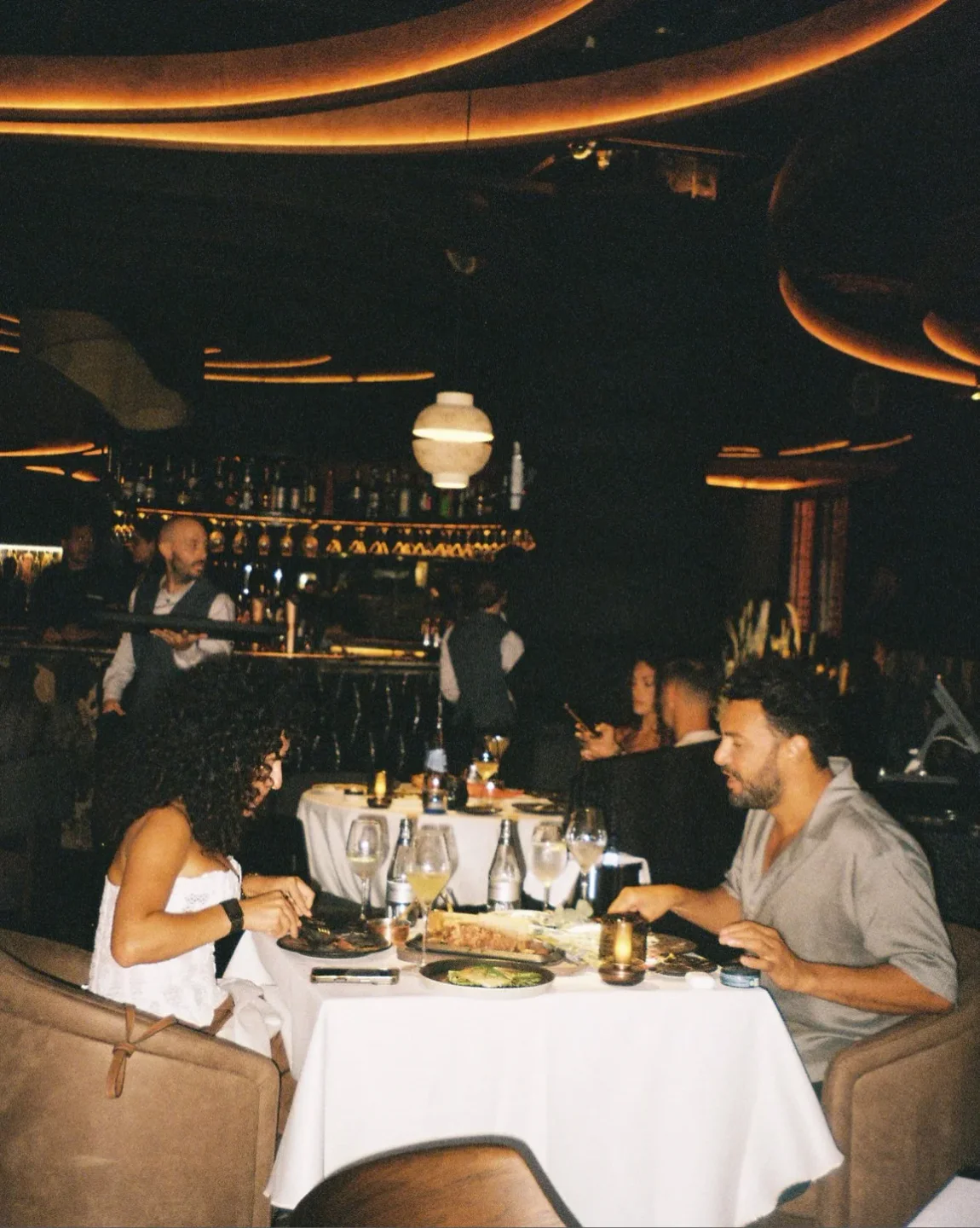 Couple enjoying a fine dining experience at Leña restaurant in Ibiza with ambient lighting.