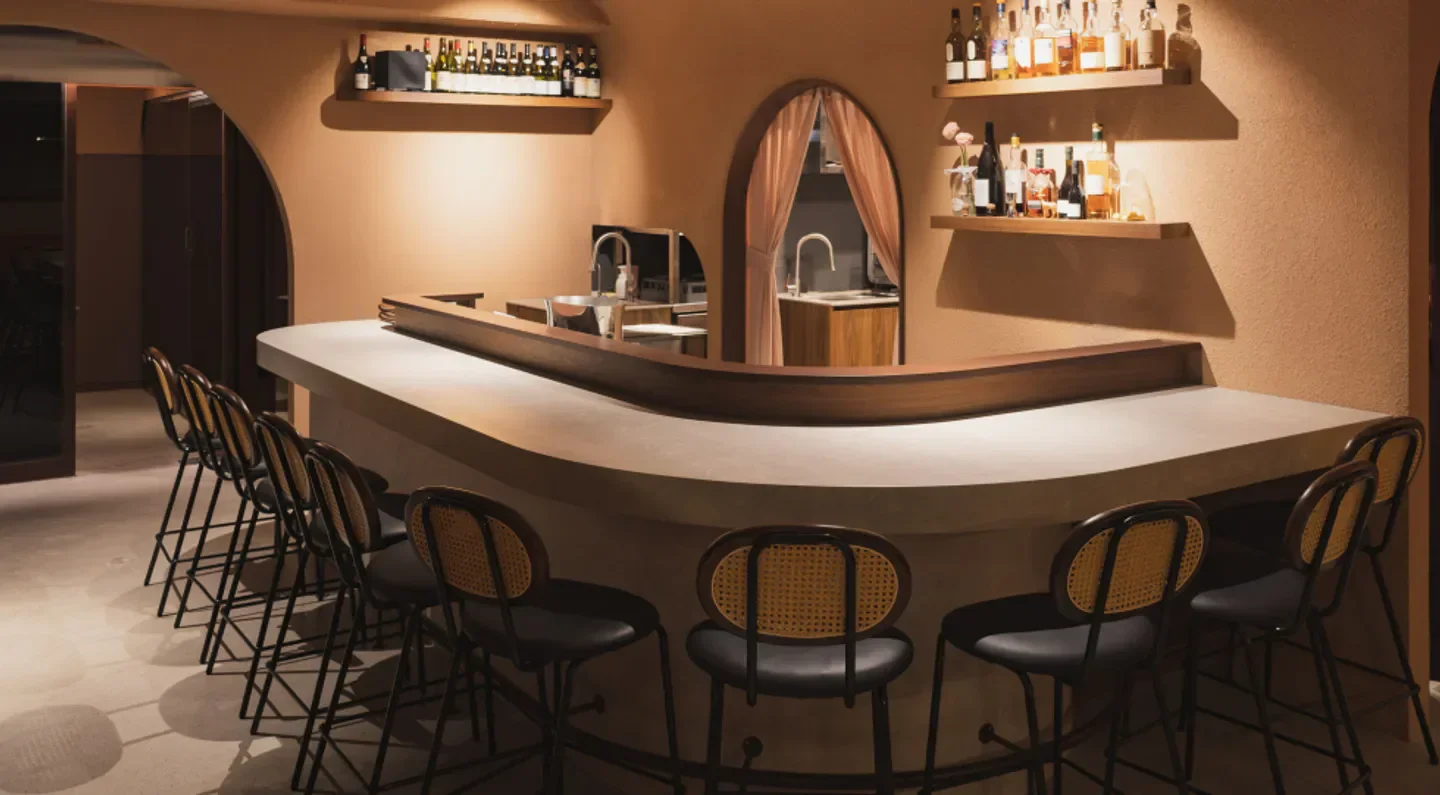Interior bar at Les Copains restaurant in Seoul, featuring stylish chairs and curved counter