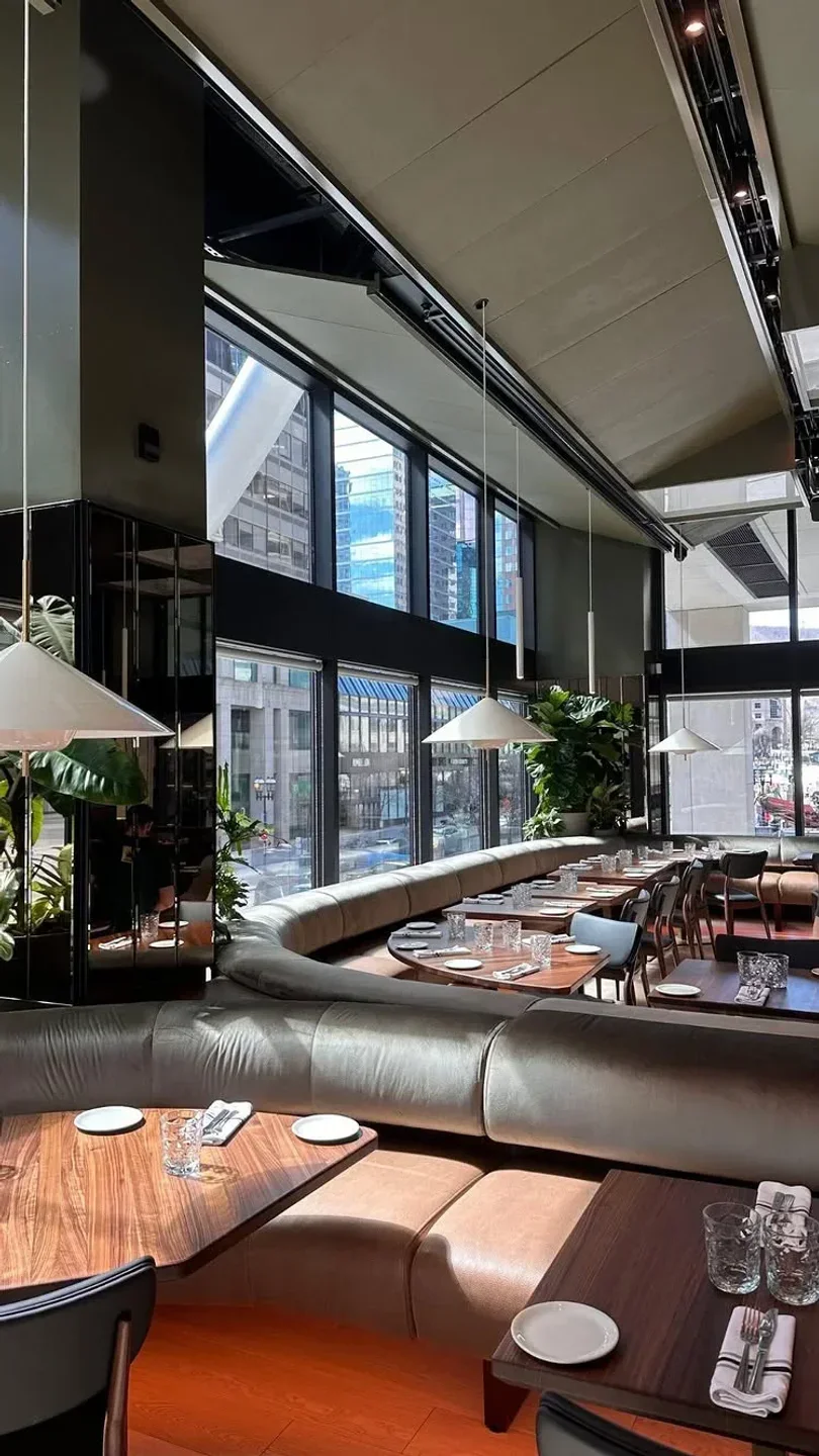 Interior of Les Enfants Terribles restaurant in Montreal, with city views and elegant decor