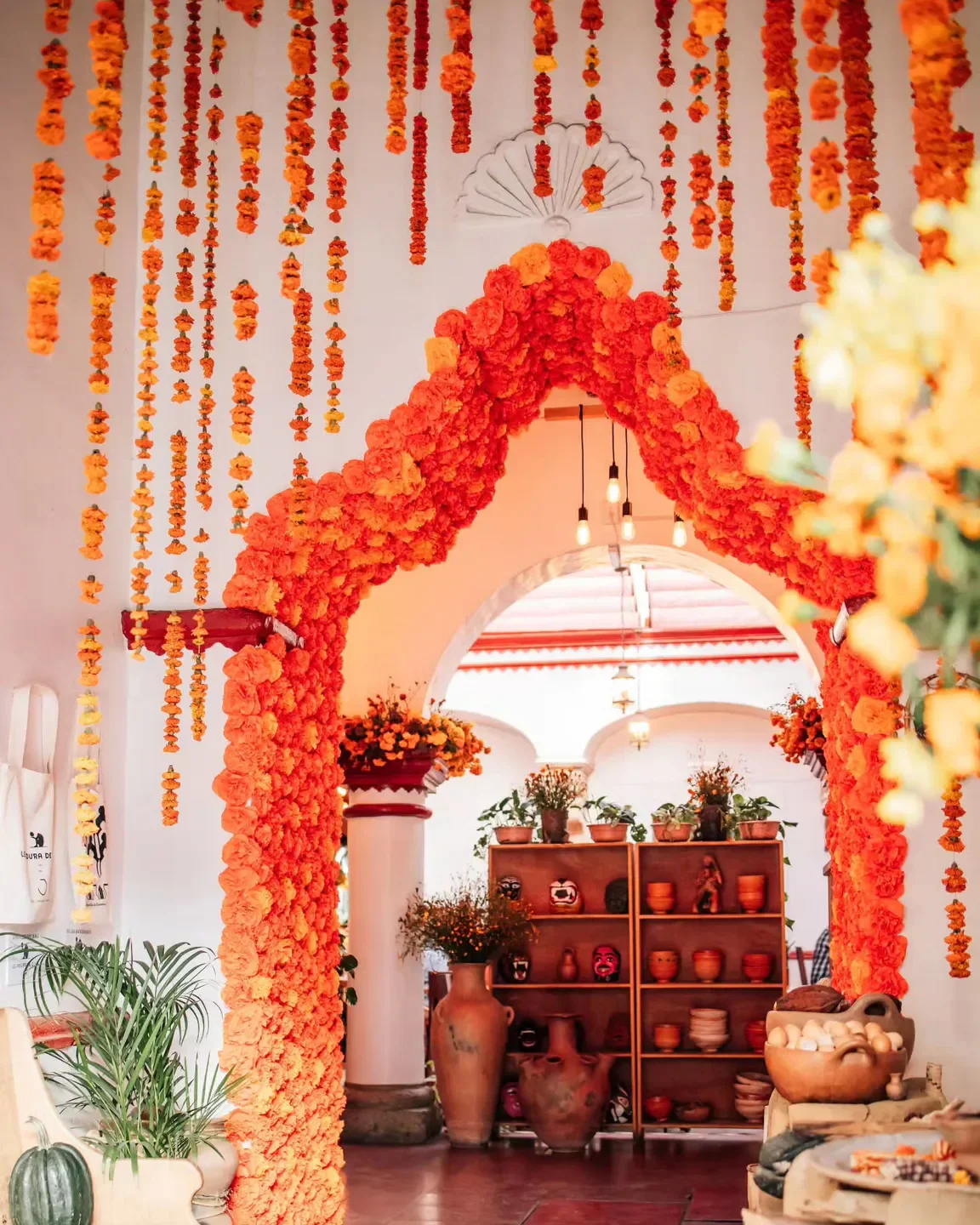 Levadura de Olla Restaurante in Oaxaca, vibrant orange flower archway and festive decor.