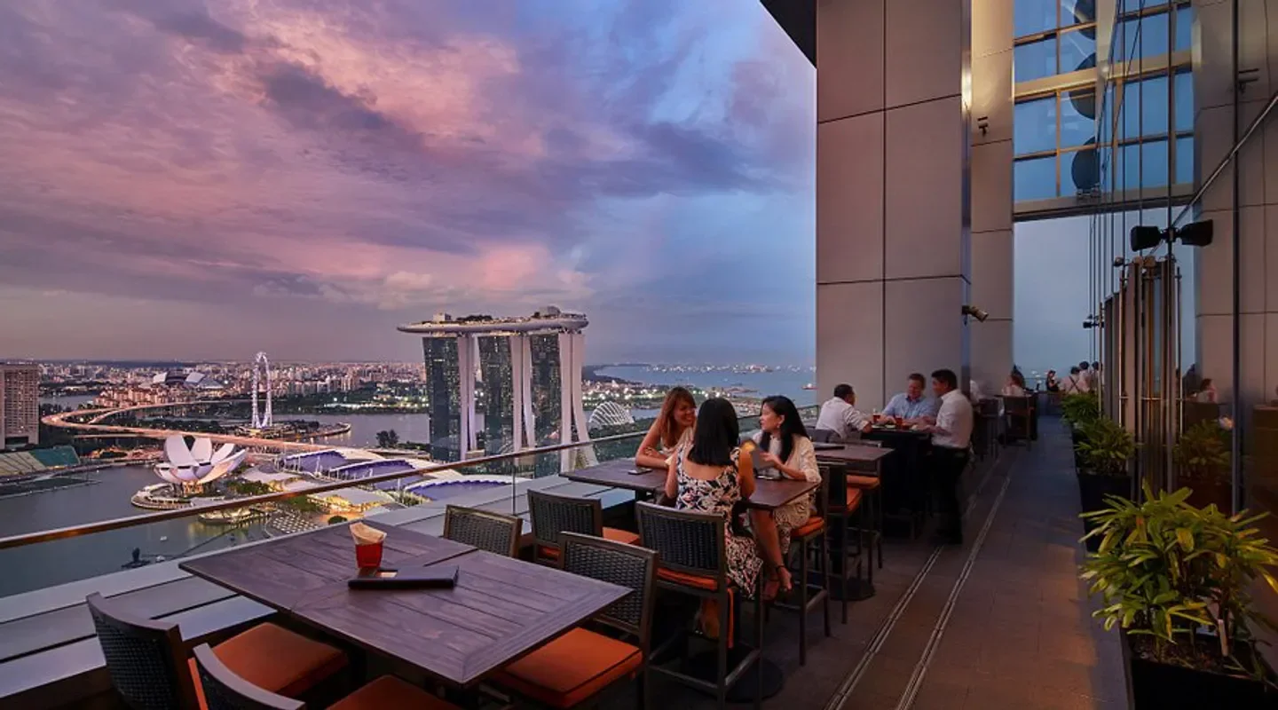 Dining at Level 33 restaurant in Singapore with city skyline views at sunset