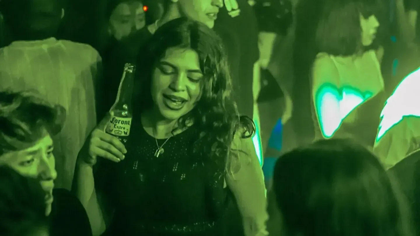 Partygoer at Levels Vancouver nightclub holding a beer, enjoying the nightlife.