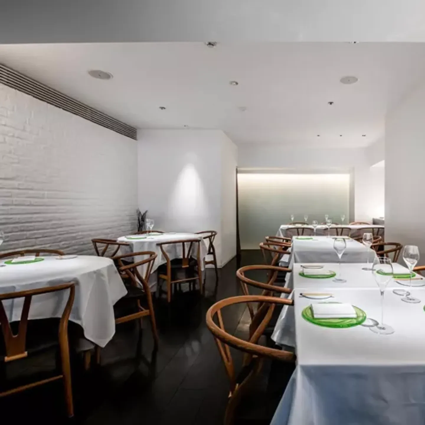 Elegant dining room interior at Liaison restaurant in Osaka, featuring white tablecloths.