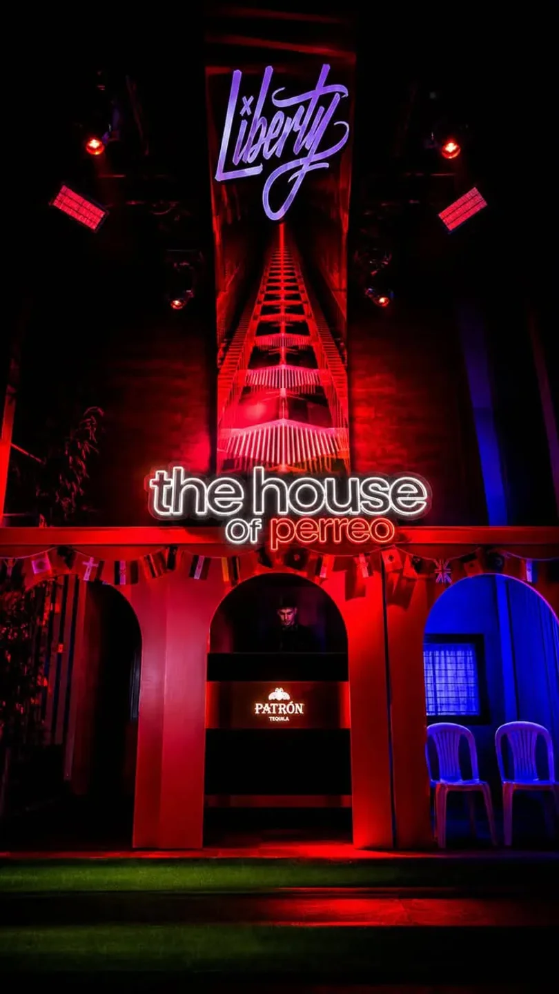 Liberty Club in the city, Spain, features neon "the house of perreo" sign and vibrant red and blue lighting.