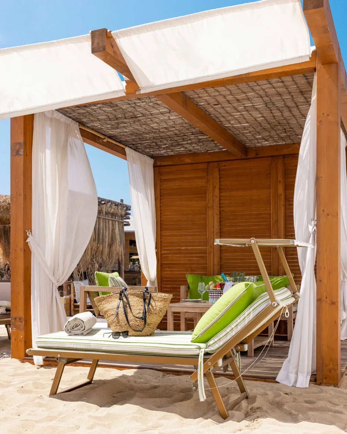 Lido Bambu beach club in Puglia offers a luxurious cabana with beach chairs and stunning ocean views.