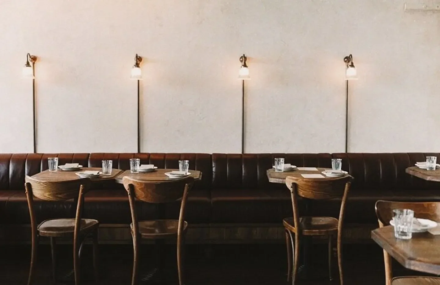 Interior of Lilian restaurant in Auckland, with wooden tables and leather booth seating
