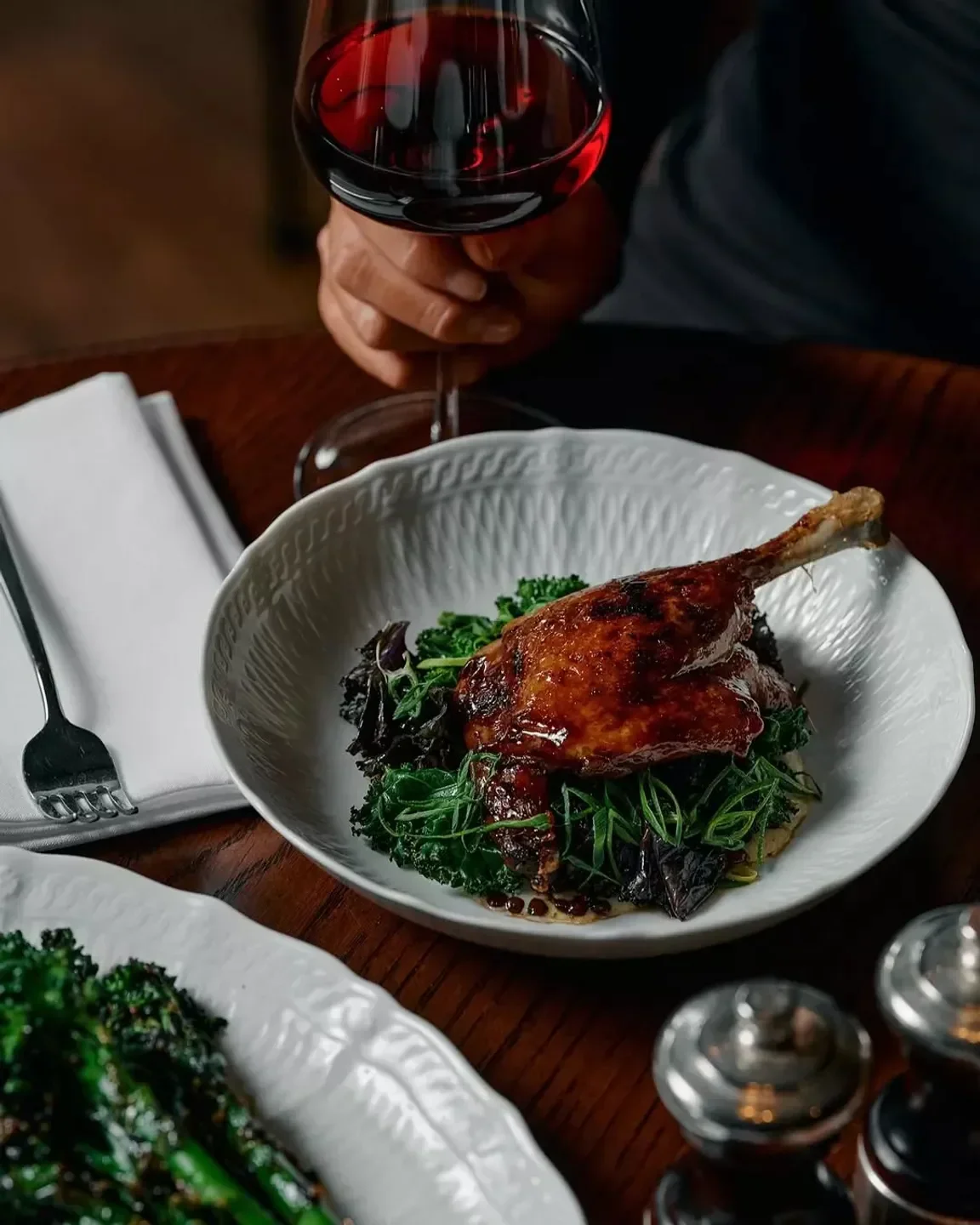 Delicious duck dish at Lillian Brasserie in Melbourne, alongside a glass of red wine.