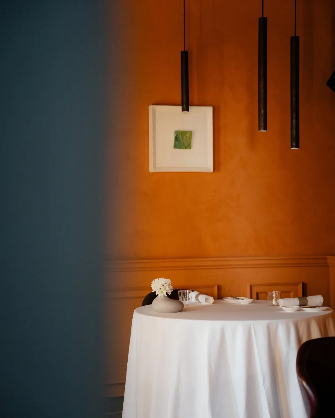 Limu Restaurant Sicily dining room with a table set for two and modern pendant lights.