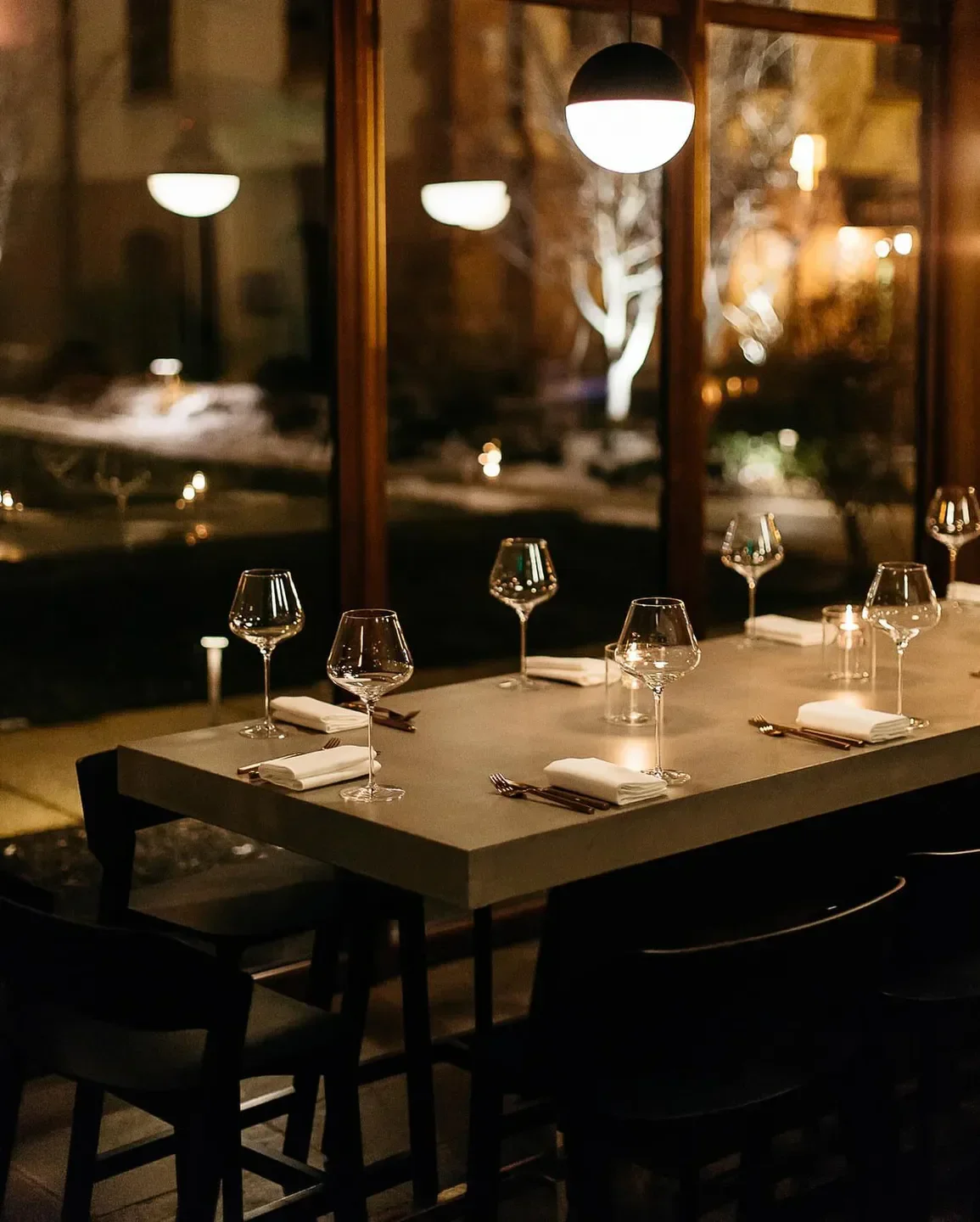 Cozy table setting at Little Pearl restaurant in Washington with wine glasses and ambiance.