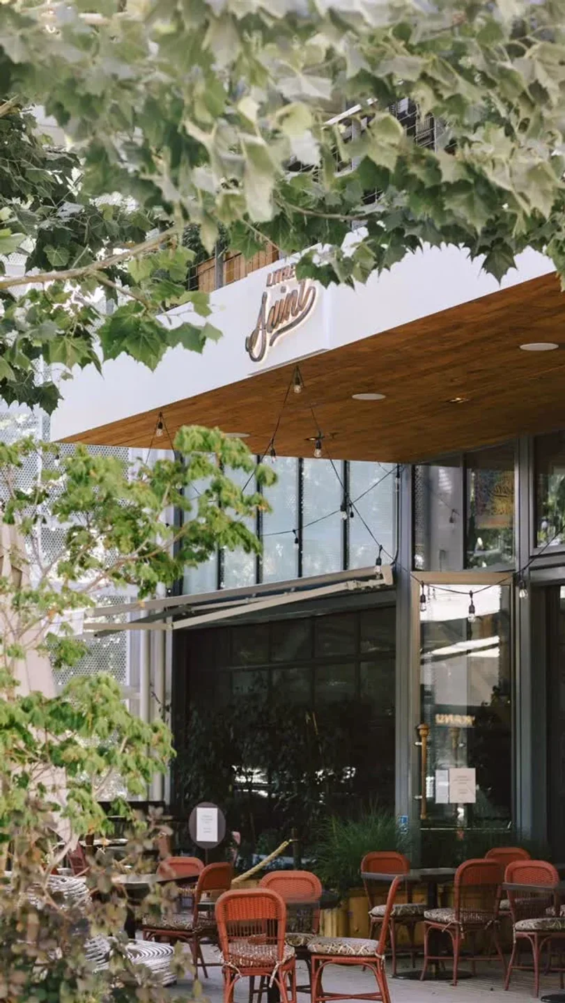 Exterior of Little Saint restaurant in Healdsburg with outdoor seating and lush greenery.
