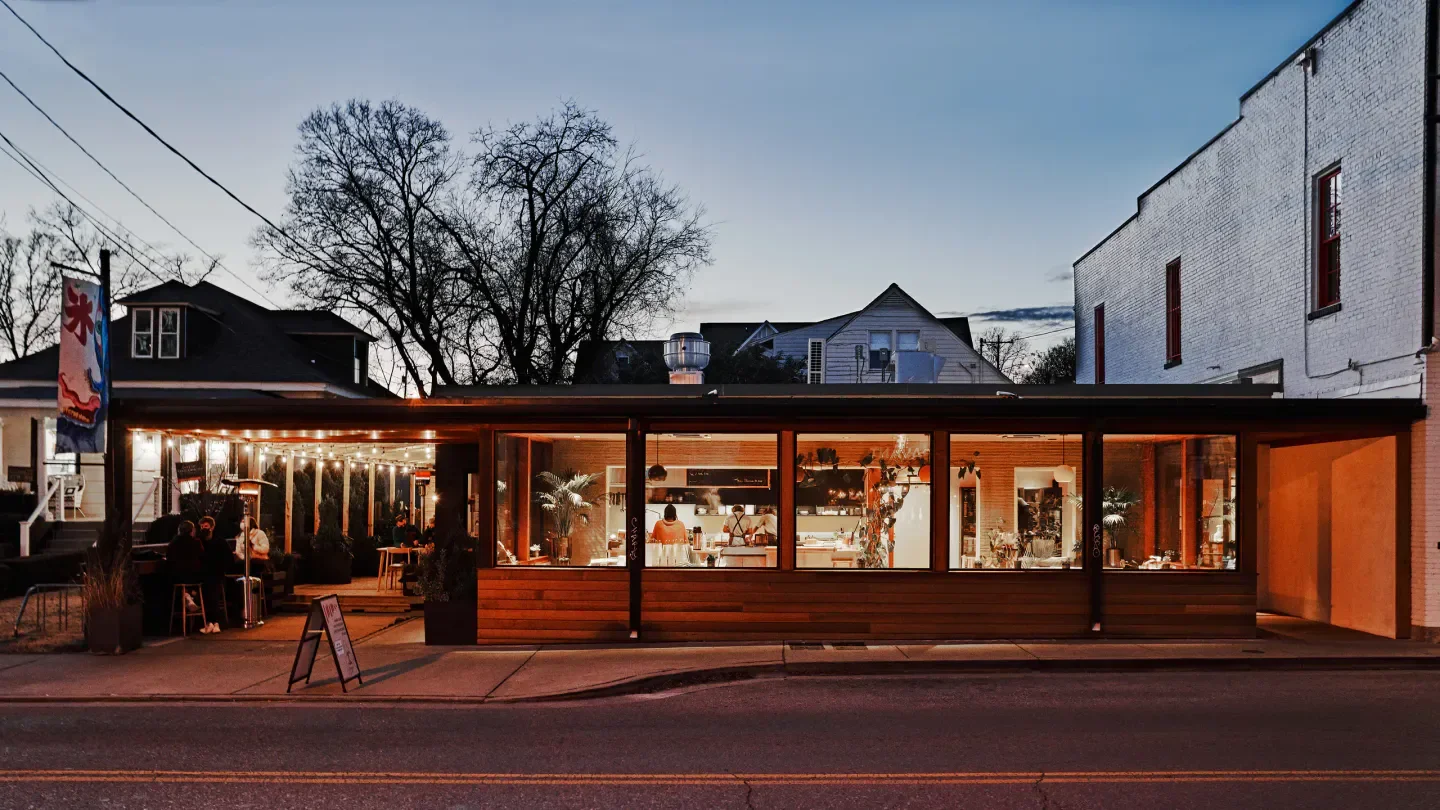 Exterior of Locust restaurant in Nashville, showing seating area and kitchen through windows