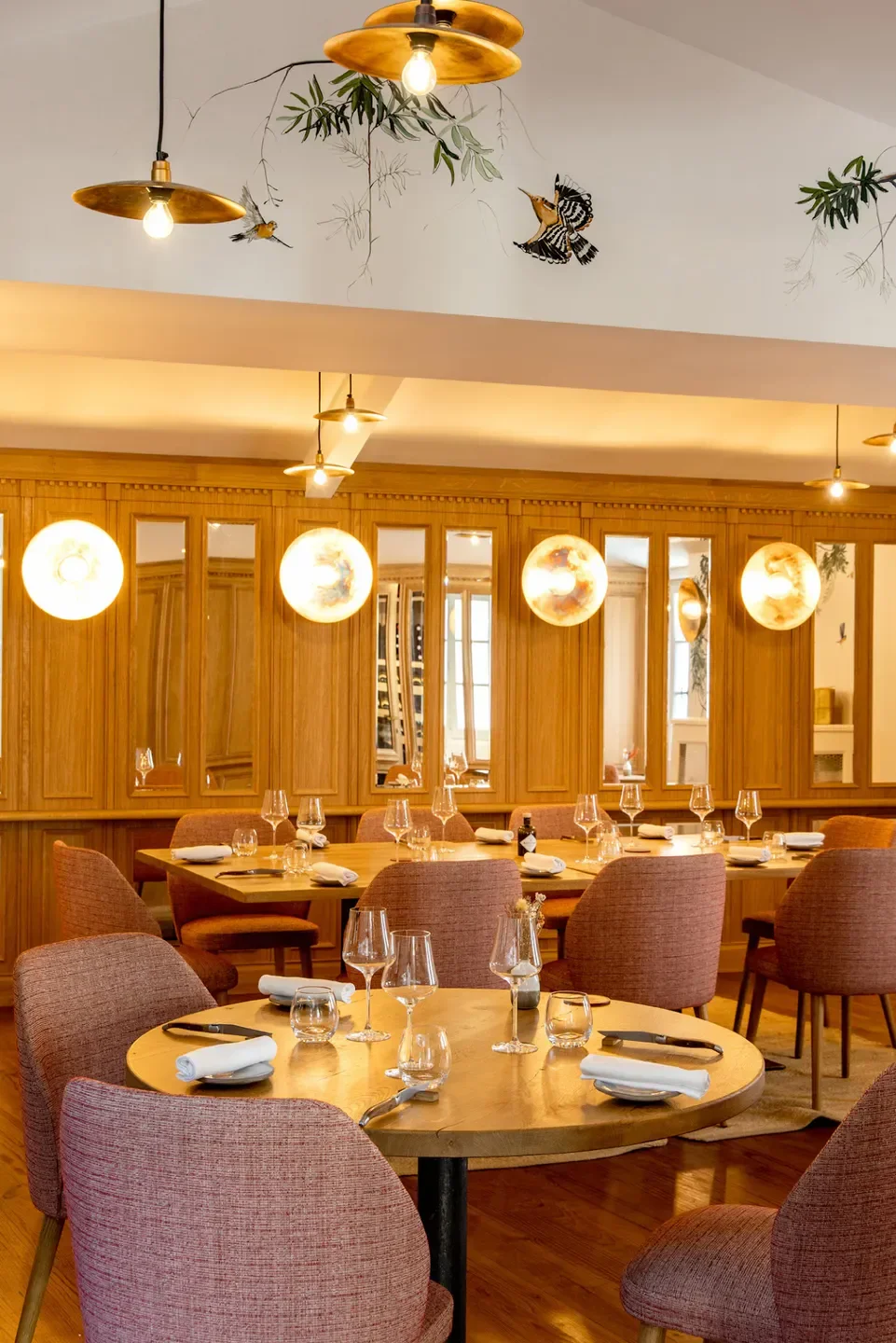 Elegant dining room at Logis de la Cadène restaurant in Bordeaux, with bird decor.