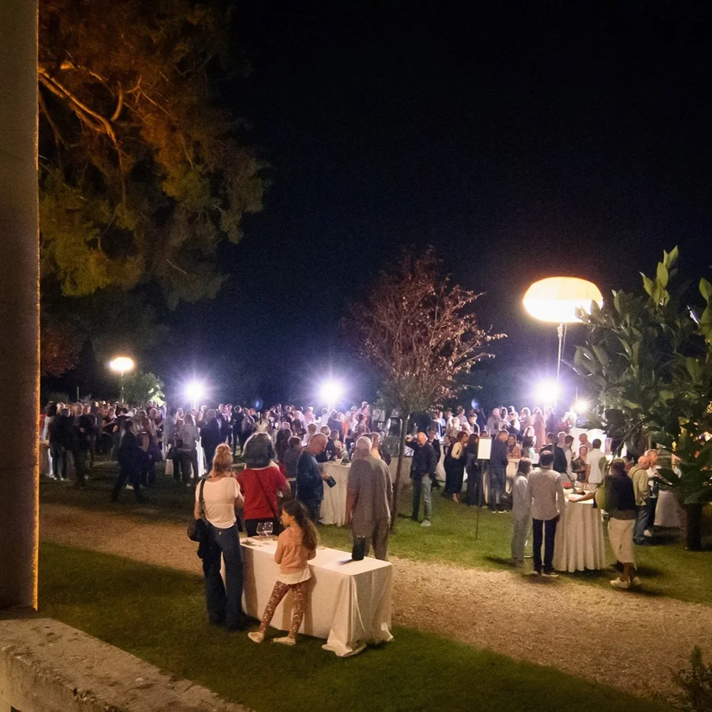 Outdoor evening event at Lokanda Devetak 1870 in Friuli-Venezia Giulia, Italy, featuring a large gathering of people and ambient lighting.