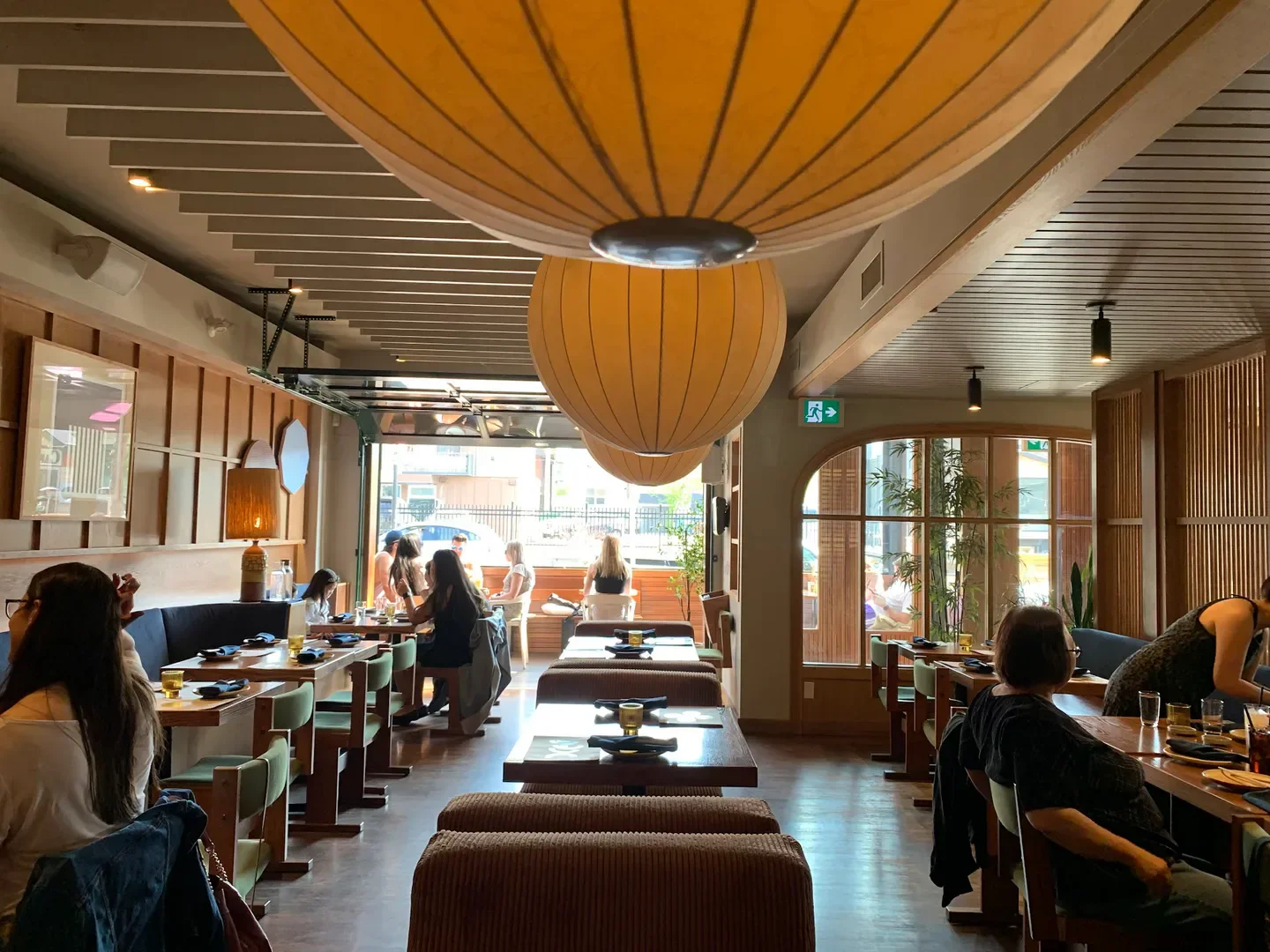Interior of Lonely Mouth Bar in Calgary with customers dining under unique light fixtures.