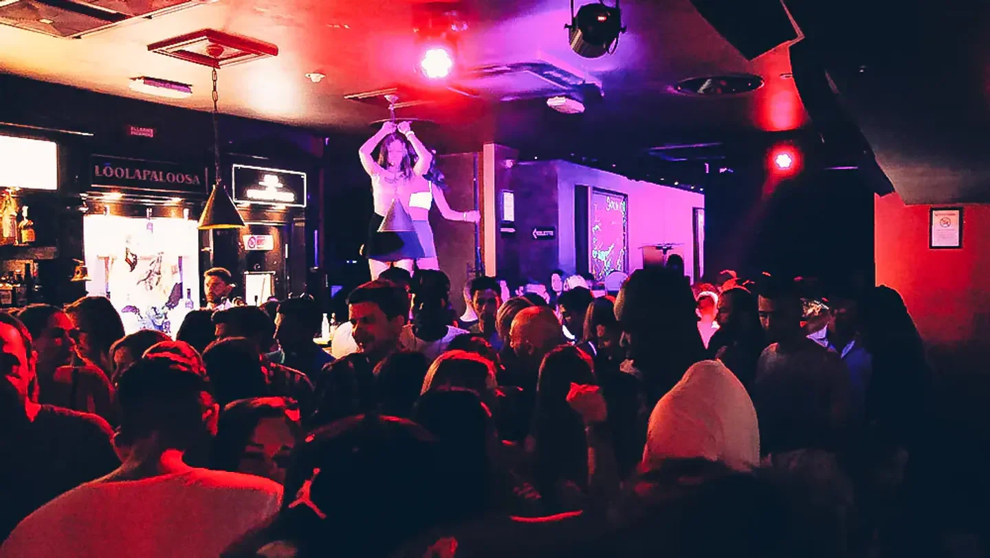 Energetic nightclub scene at LoolaPaloosa in Milan, with a crowd and stage performance.