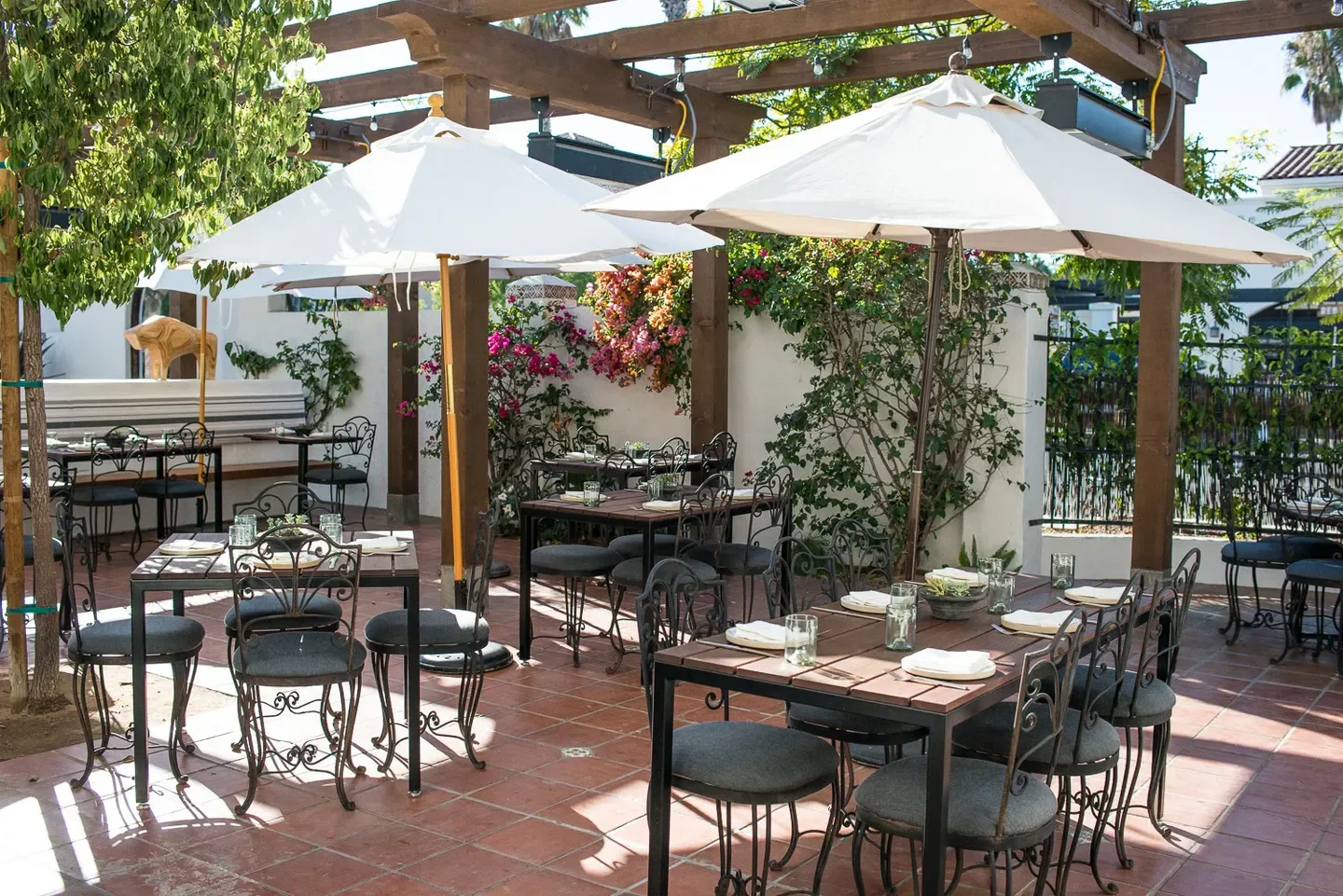 Outdoor dining at Loquita Santa Barbara, with umbrellas and a charming patio setting.