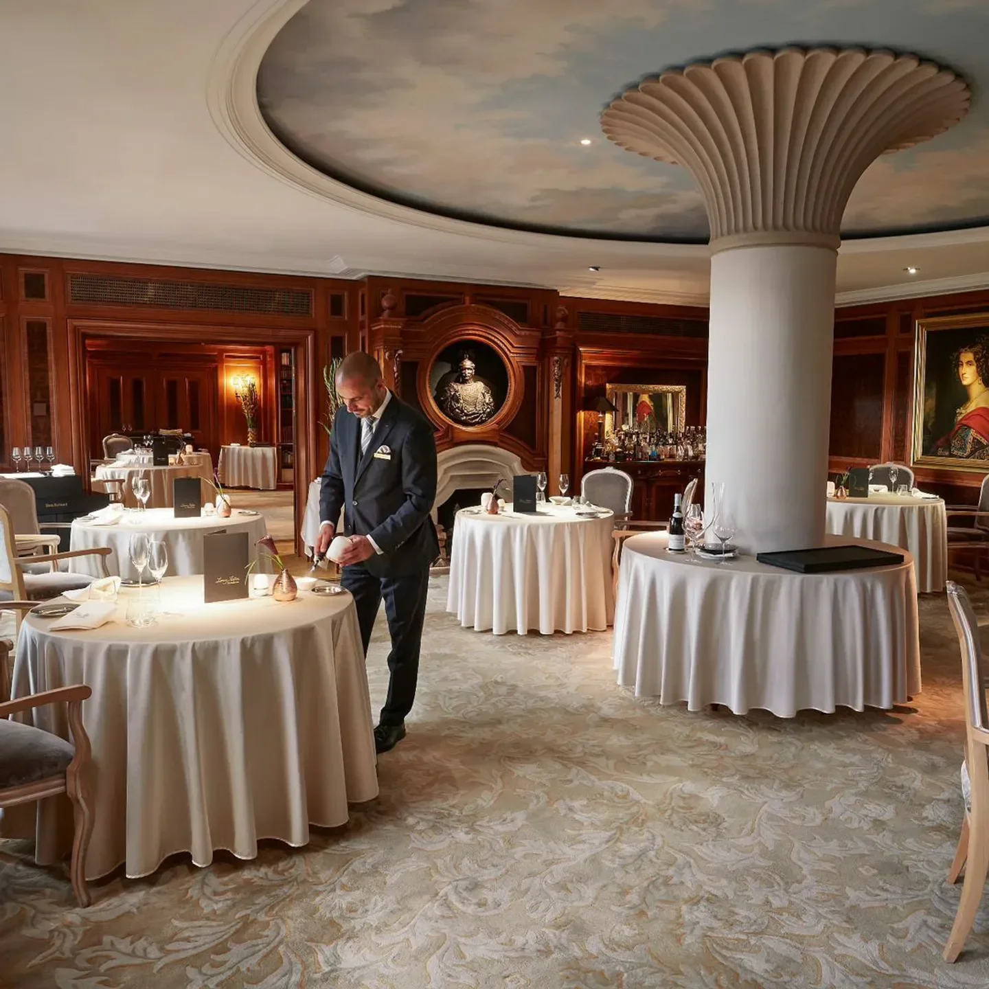 Elegant interior of Lorenz Adlon Esszimmer restaurant in Berlin with a waiter at work