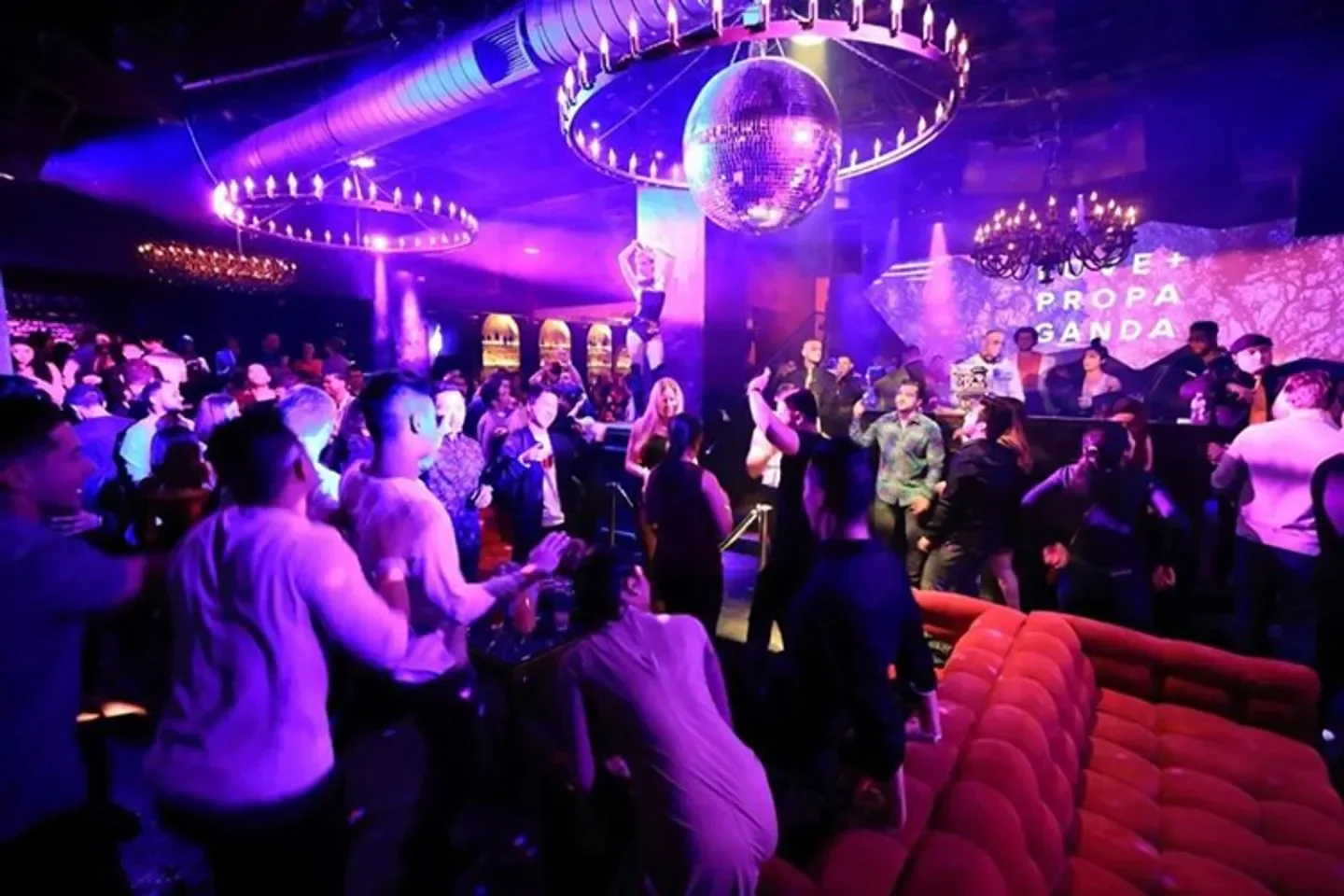 Dancing crowd at Love and Propaganda nightclub in San Francisco under disco balls