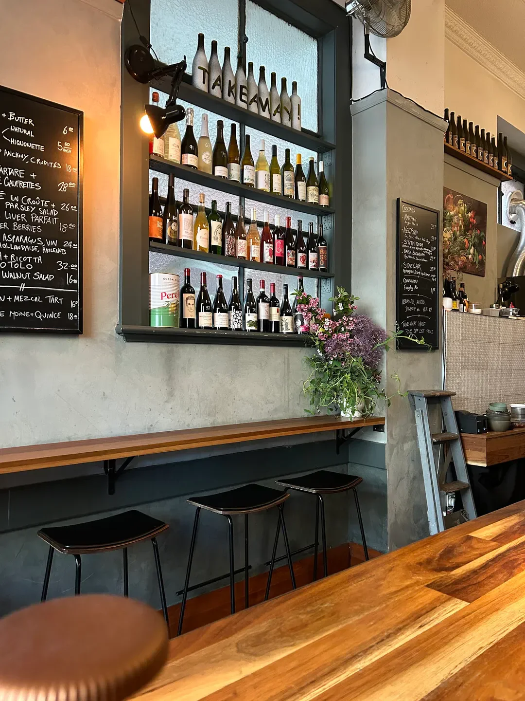 Interior of Lucinda Wine Bar in Hobart, showcasing wine bottles and bar seating.