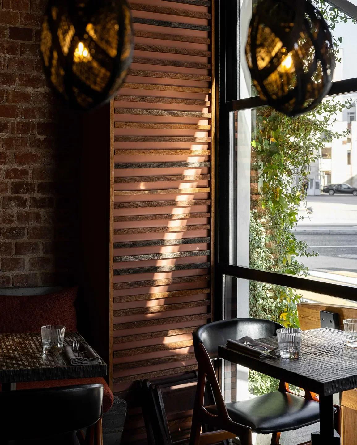 Cozy interior at Lucky Izakaya in Moscow, featuring a brick wall and natural light.