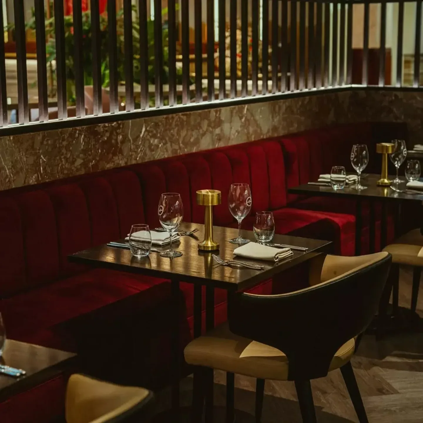 Elegant dining interior at Luke's Kitchen in Sydney, with red booths and stylish tables.