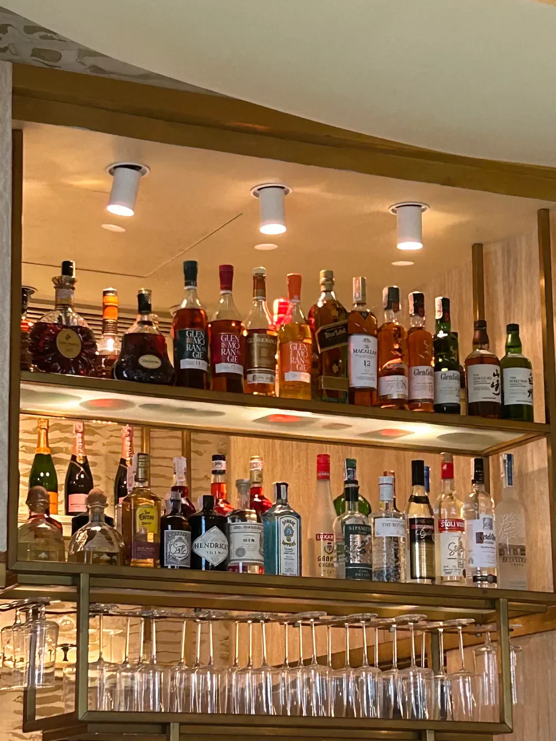 Well-stocked bar at Lusso by Margarita Forés, Manila, featuring various spirits and glassware.