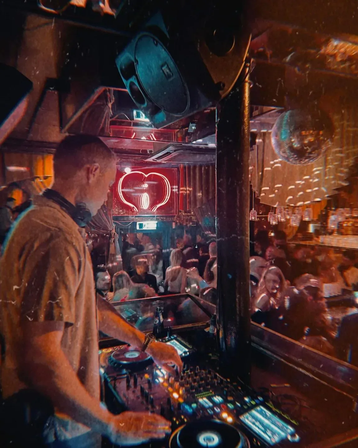 DJ at Lusso nightclub in Copenhagen, playing for a lively crowd under the lights.