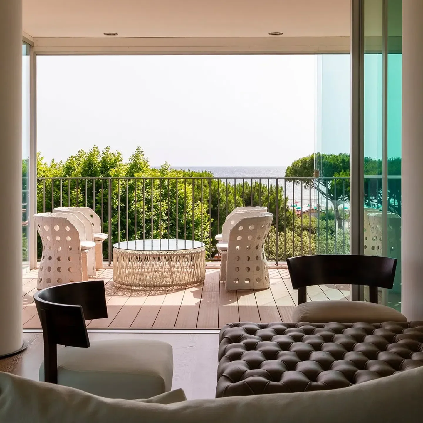 Outdoor terrace at Lux Lucis restaurant in Tuscany, overlooking the sea and lush greenery.