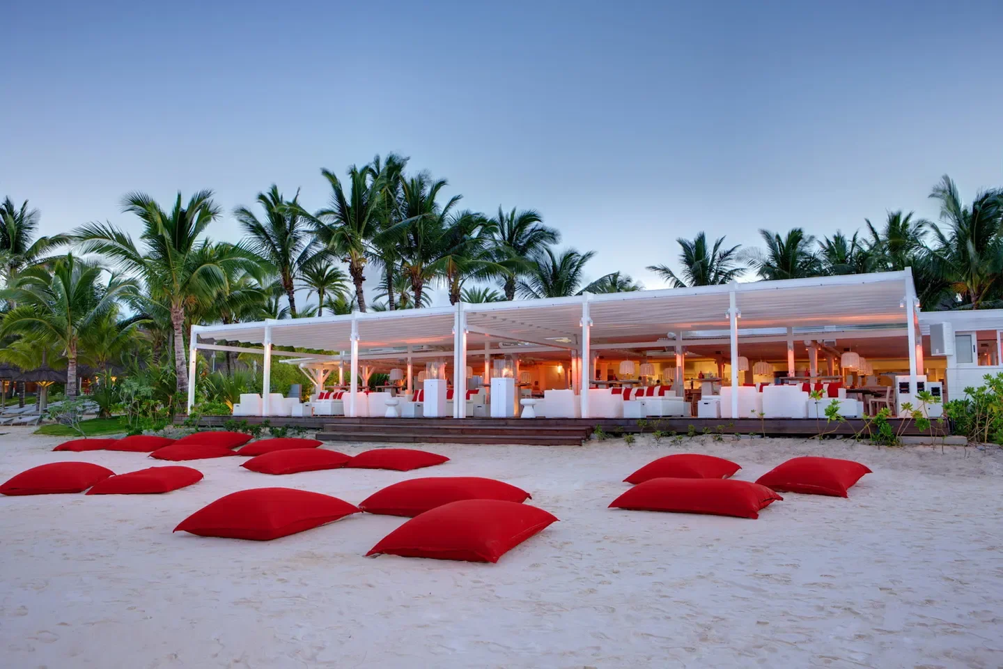 Beachfront view of LUX* ME Spa at Belle Mare in Poste de Flacq with red cushions.