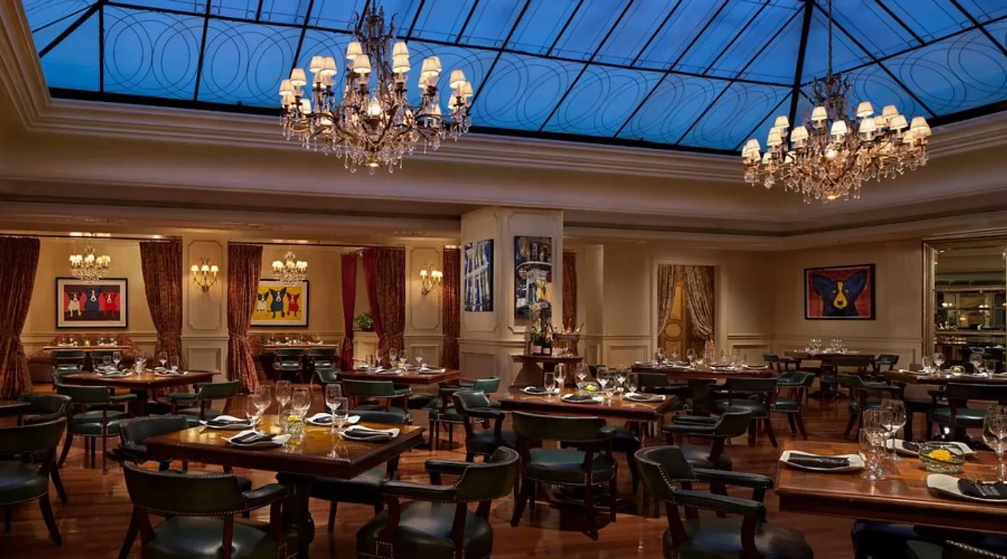 Elegant interior of M Bistro in New Orleans, with chandeliers and dining tables.