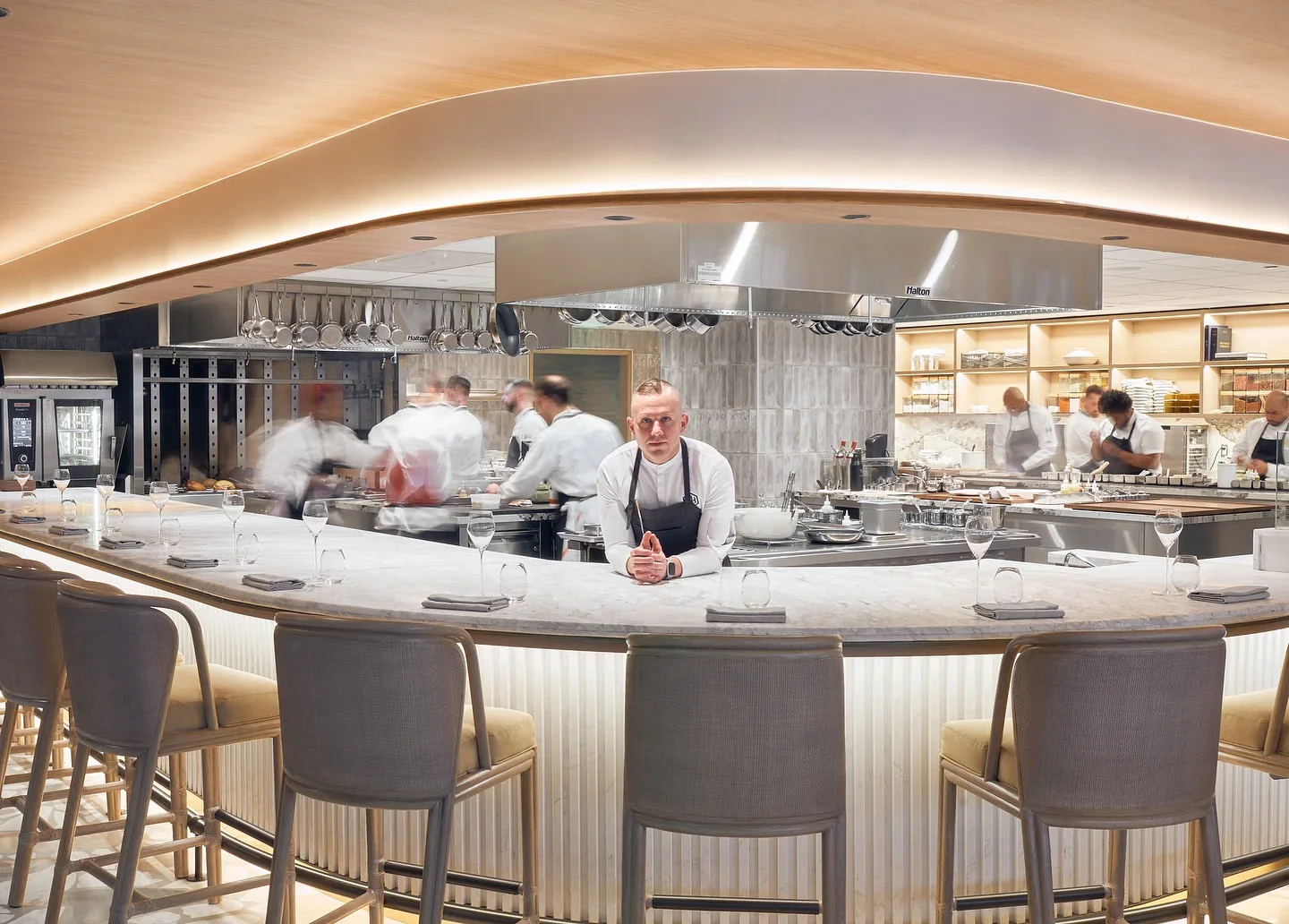 Interior of MAASS by Ryan Ratino in Fort Lauderdale, featuring a chef and open kitchen with a bar setting.