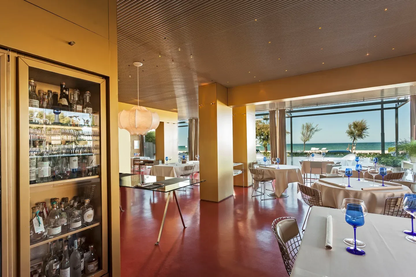 Interior dining at Madonnina del Pescatore restaurant in Marche, with sea views.