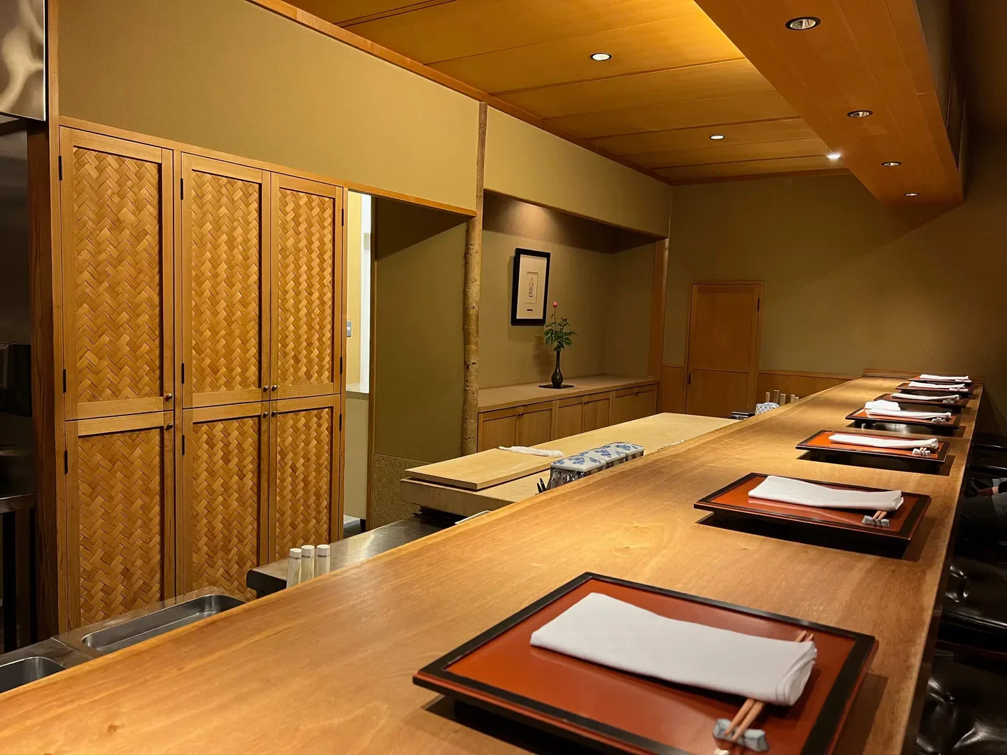 Interior of Maeda restaurant in Kyoto, with sushi bar and woven cabinet details.
