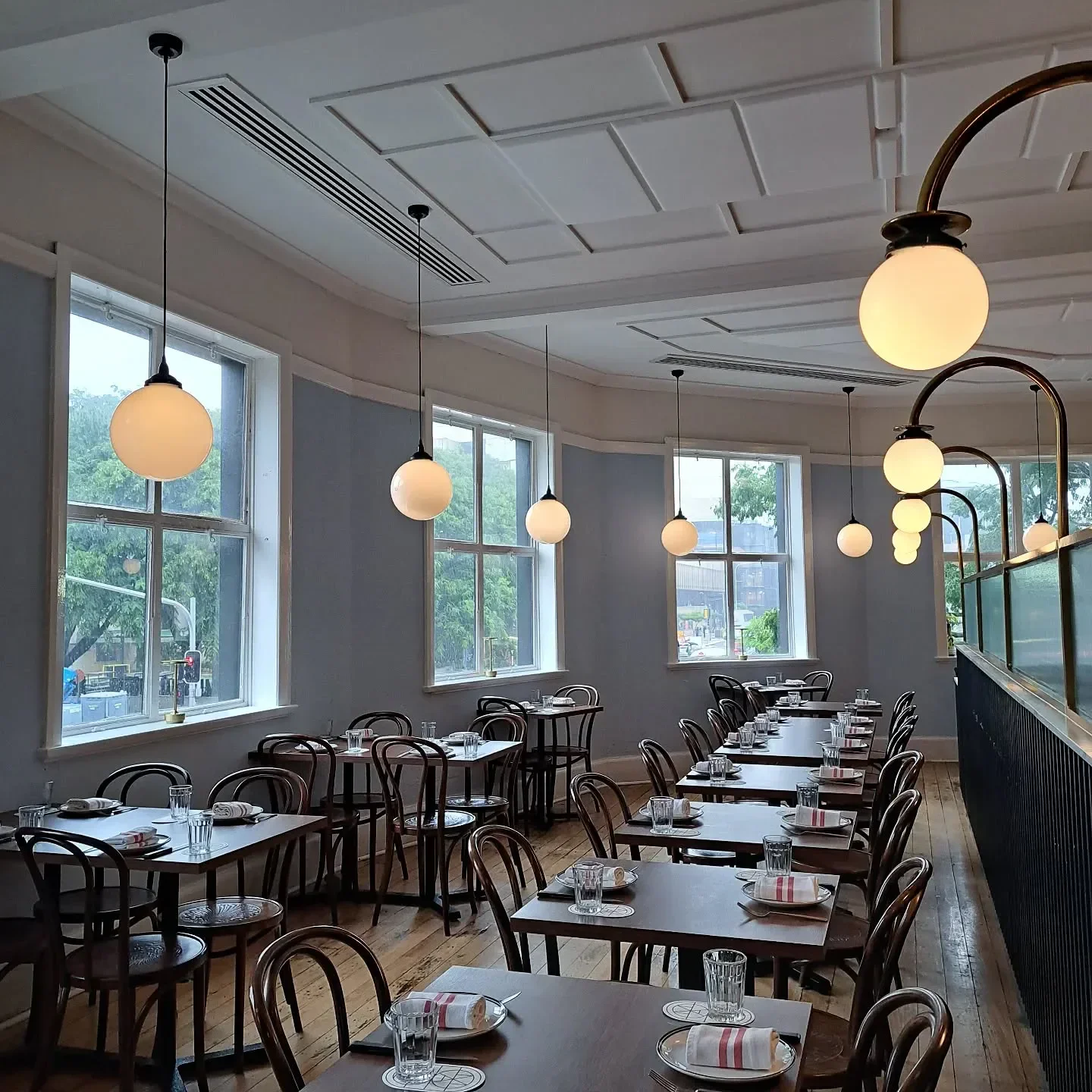 Interior of Maeve Wine restaurant in Brisbane, showcasing tables, chairs, and elegant lighting.
