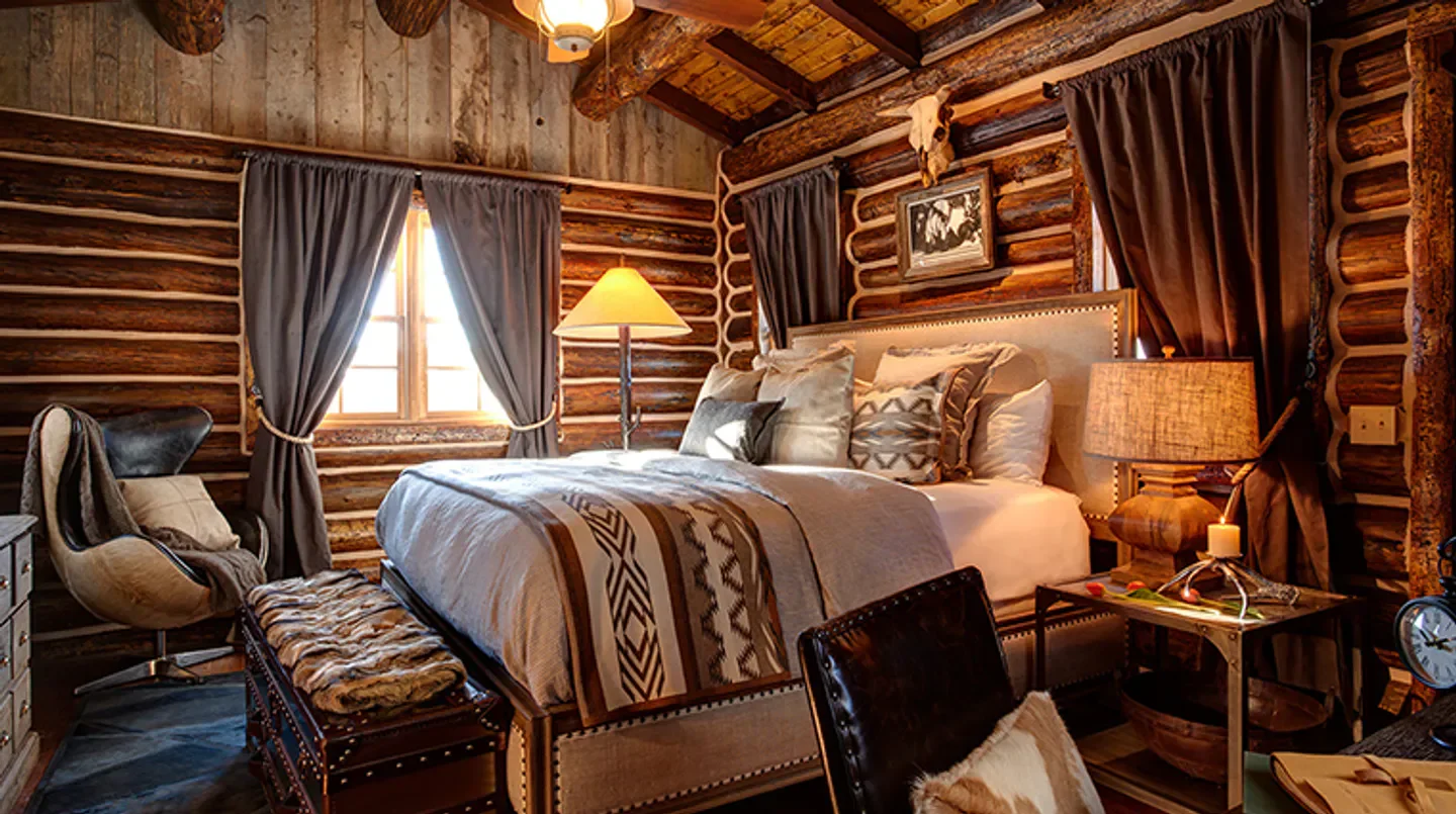 Cozy bedroom at Magee Homestead in Saratoga, featuring log walls and rustic decor.