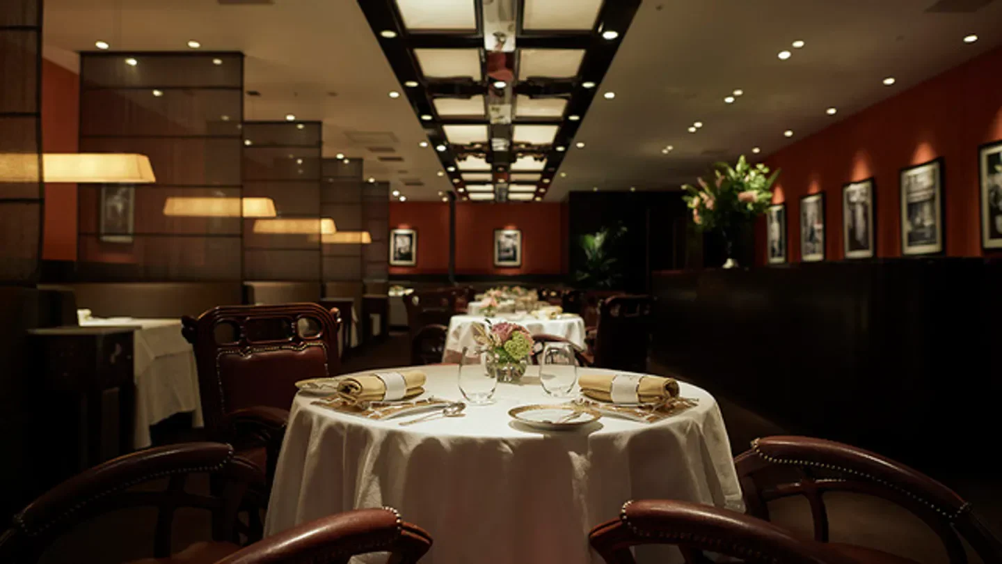 Elegant dining room interior at Maison Paul Bocuse in Tokyo, tables set for fine dining.