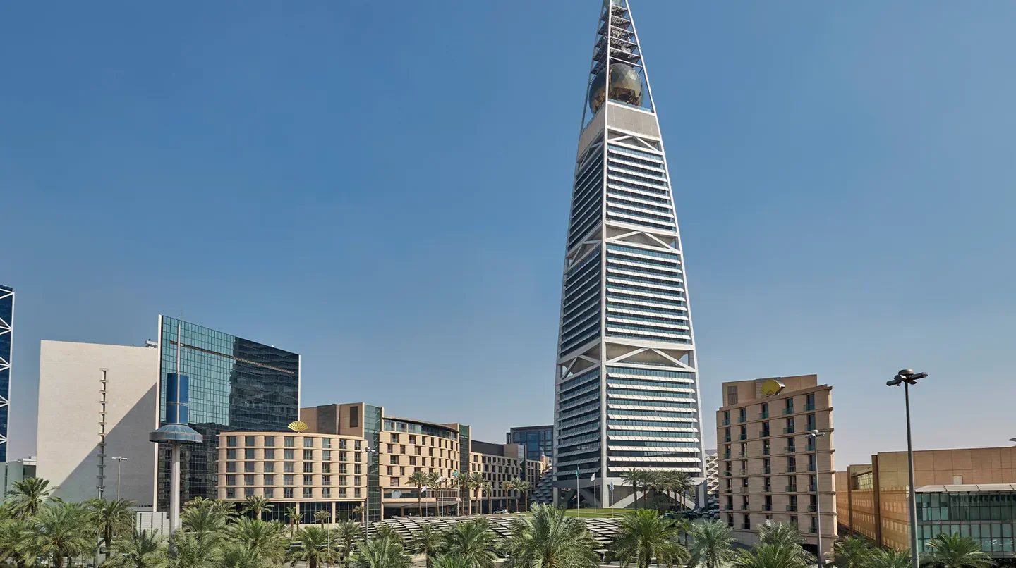 Exterior view of the Mandarin Oriental Al Faisaliah Hotel in Riyadh, with palm trees.