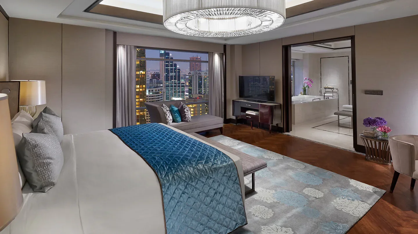 Mandarin Oriental, Kuala Lumpur bedroom with city view in Kuala Lumpur at night.