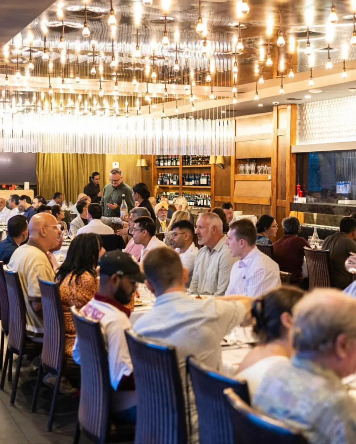 Dining at Manjits Wharf restaurant in Sydney, under decorative lighting and a lively atmosphere.