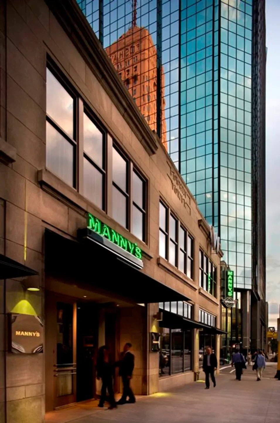Exterior of Manny's Steakhouse in Minneapolis, showcasing modern architecture and neon signage.